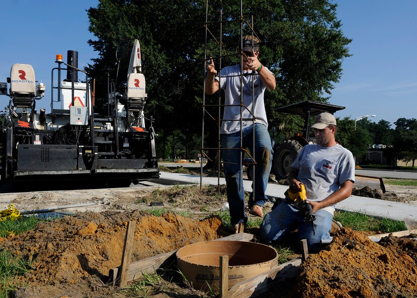 MOODY AIR FORCE BASE, Ga. -- Jacob Jarbin and Christopher Tucker, electricians with Etheridge Electric Company, install frames for lights in the Medical Group parking lot here Aug. 28. The frames have to be installed before the concrete can be poured. (U.S. Air Force photo by Senior Airman Brittany Barker)