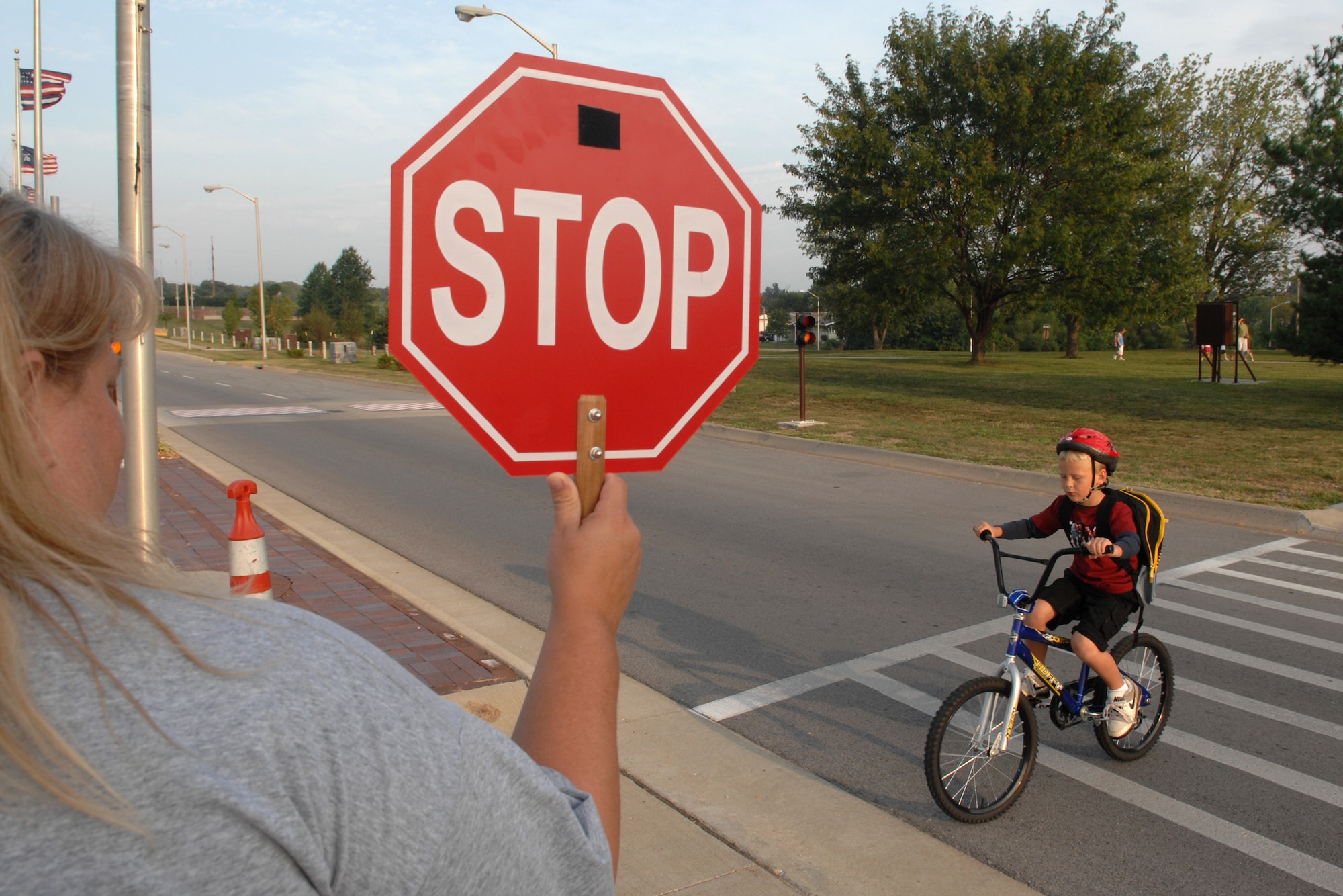 WHITEMAN AIR FORCE BASE, Mo – Mrs. Tonya Walher, a crosswalk guard, holds up a stop sign bringing traffic to a halt so a child can safely make his way to school Aug. 28.  School is back in session and that, coupled with the increased traffic flow caused by the Arnold Gate closure, makes crosswalk safety imperative. (U.S. Air Force photo/Senior Airman Jessica Snow)

