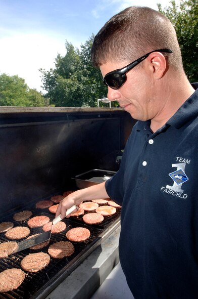 FAIRCHILD AIR FORCE BASE, Wash. – Master Sgt. Todd Berliner, 92nd Maintenance Operations Squadron first sergeant, cooks hotdogs and hamburgers at the dorm picnic. The picnic took place on Aug. 22 and was sponsored by the Fairchild First Sergeants Association. “This is our opportunity to give back to the Airmen living in base dormitories,” said Sergeant Berliner. The picnic hosted volleyball games, music and visits from senior leadership. (U.S. Air Force photo / Staff Sgt. JT May III)