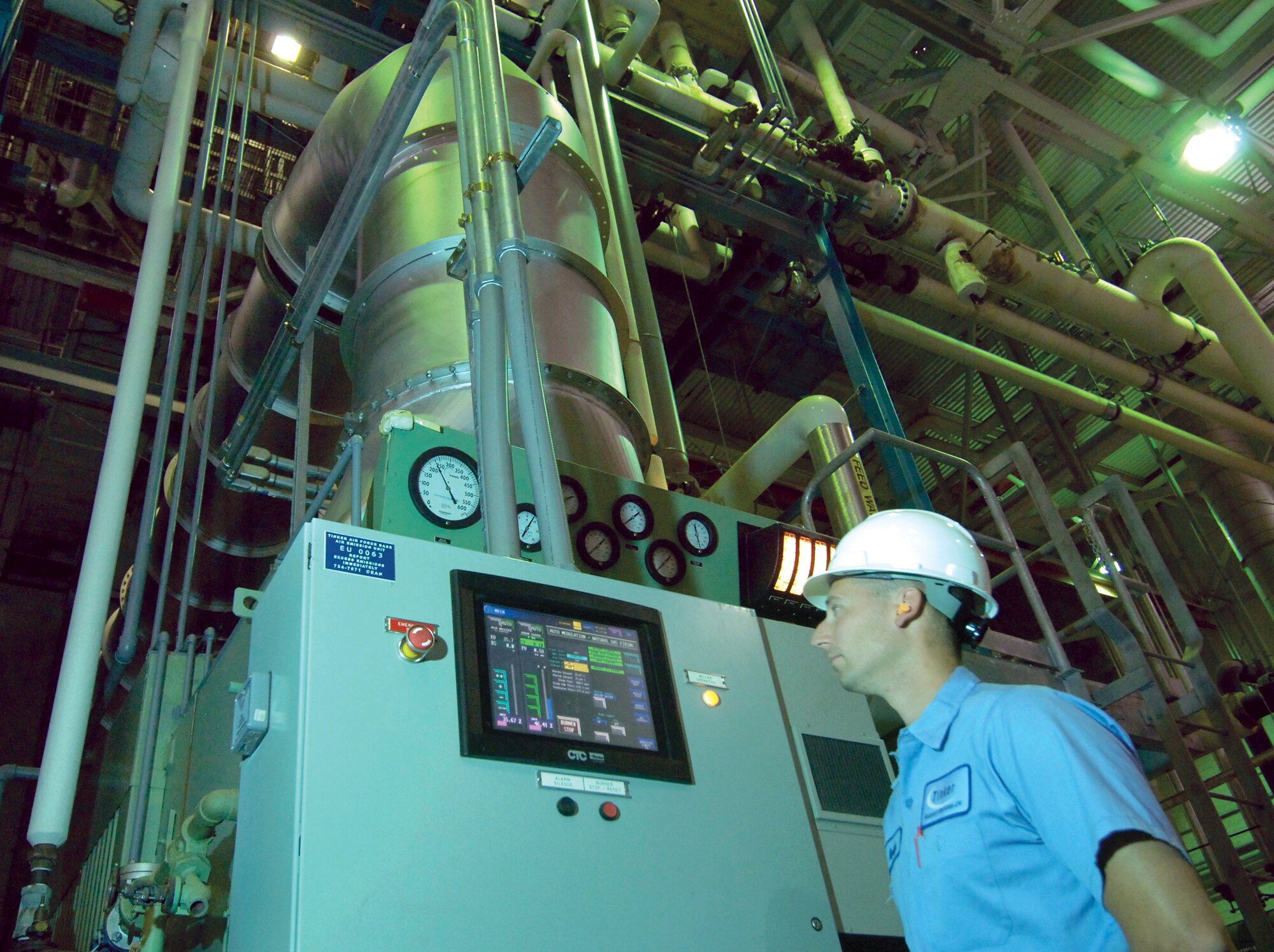 Boiler operator Andy Calise monitors one of four nearly 40-feet tall boilers in the main steam plant located in Bldg. 3001.  Boilers act like huge pressure cookers, heating water to 246 degrees under 62,000 to 100,000 pounds of pressure an hour, depending on the boiler. The steam continuously  supplies maintenance shops like plating or chemical cleaning with power to operate critical equipment.  Seven equally  mammoth chillers, some with pipes 42 inches in diameter,  bring air conditioning throughout Bldg. 3001 and the east side of Tinker.  Seven plants dot the base, some acting as unmanned satellites to help when demands require it.  Most boilers were installed in 1942 though updated computerized monitoring helps operators like Mr. Calise keep the giants operating safely and smoothly.  (Air Force photo/Margo Wright)