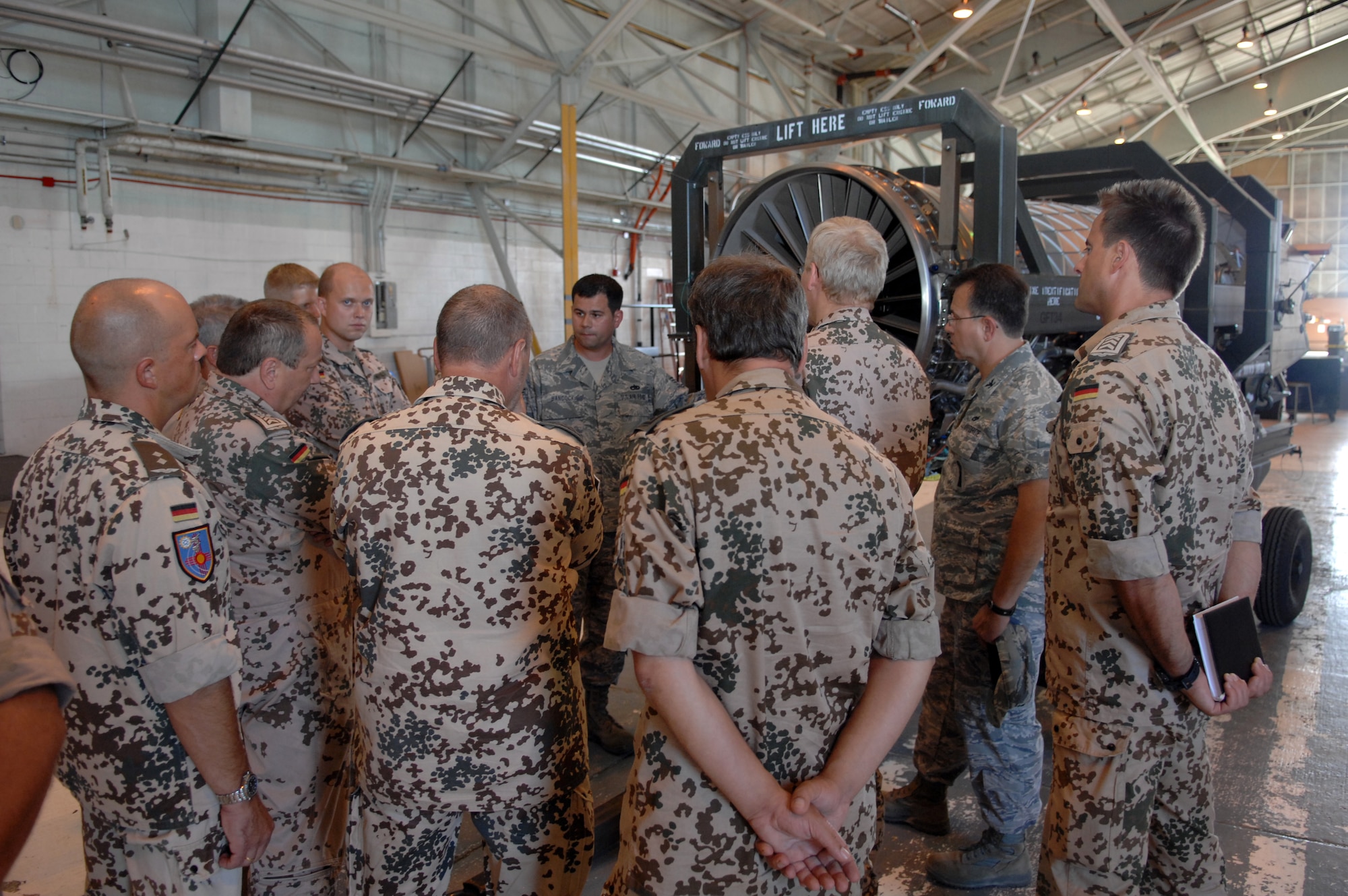 Tech. Sgt. William Hancock, 49th Maintenance Squadron, answers a question about the engine inlet and explains the integrated blade rotor construction of the F-119 engine during the German Exchange Program tour at Holloman Air Force Base, N.M., August 22. The tour was designed to show maintenance senior non-commission officers and officers of the German air force how their American counterparts carry out the same discipline.  (U.S. Air Force photo/ Airman Sondra Wieseler)