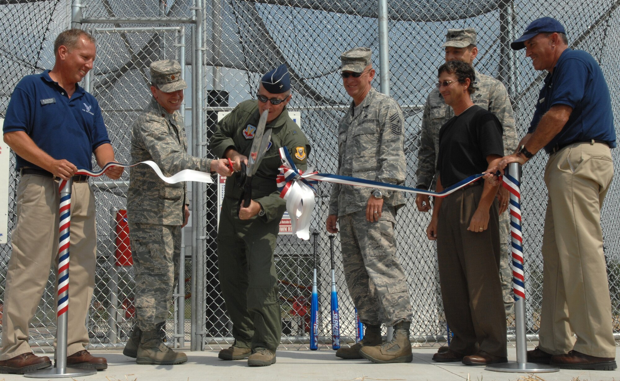 WHITEMAN AIR FORCE BASE, Mo. – Brig. Gen. Gary Harencak, 509th Bomb Wing commander, cuts the ribbon as supporters look on at the batting cages grand opening Aug. 27. The batting cages are open from sun rise to sun down and are free of charge until January. (U.S. Air Force photo/Airman 1st Class Stephen Linch)
