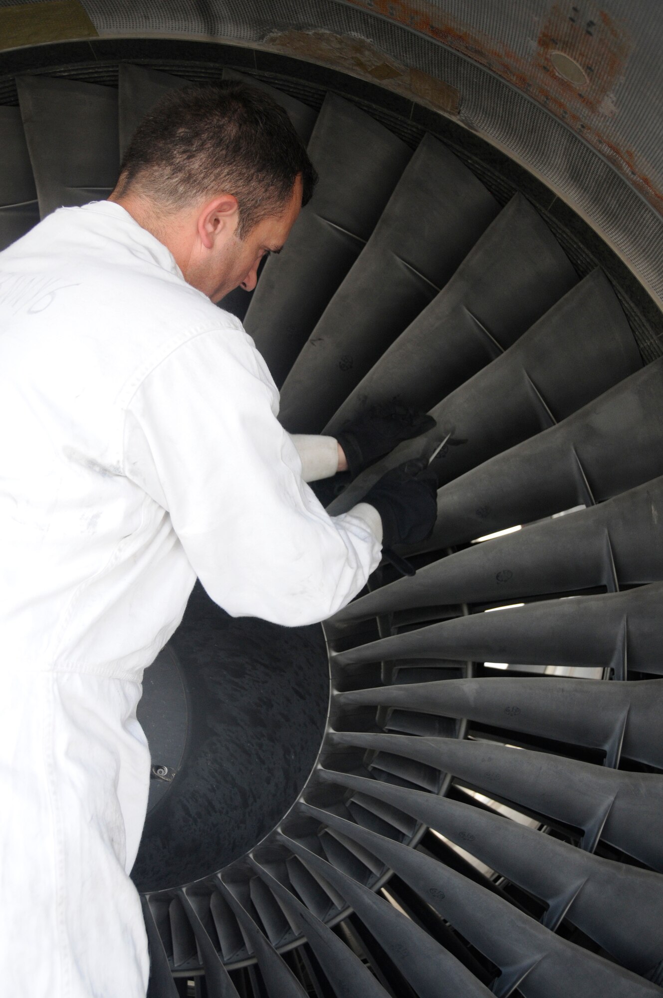 Tech. Sgt. Phillip Daniels, jet engine mechanic assigned to the 379th Expeditionary Air Mobility Squadron, files the fan blades of a C-17 engine to blend a chipped part to match the other blades Aug. 27, 2008 at an undisclosed air base in Southwest Asia. The C-17 is the U.S. Air Force's premier airlifter and is responsible for transporting equipment, supplies and personnel throughout the theater of operations, supporting Operations Iraqi and Enduring Freedom and Joint Task Force-Horn of Africa. Sergeant Parker, a native of Salisbury, N.C., is deployed from Charleston Air Force Base, S.C. (U.S. Air Force photo by Staff Sgt. Darnell T. Cannady/Released)
