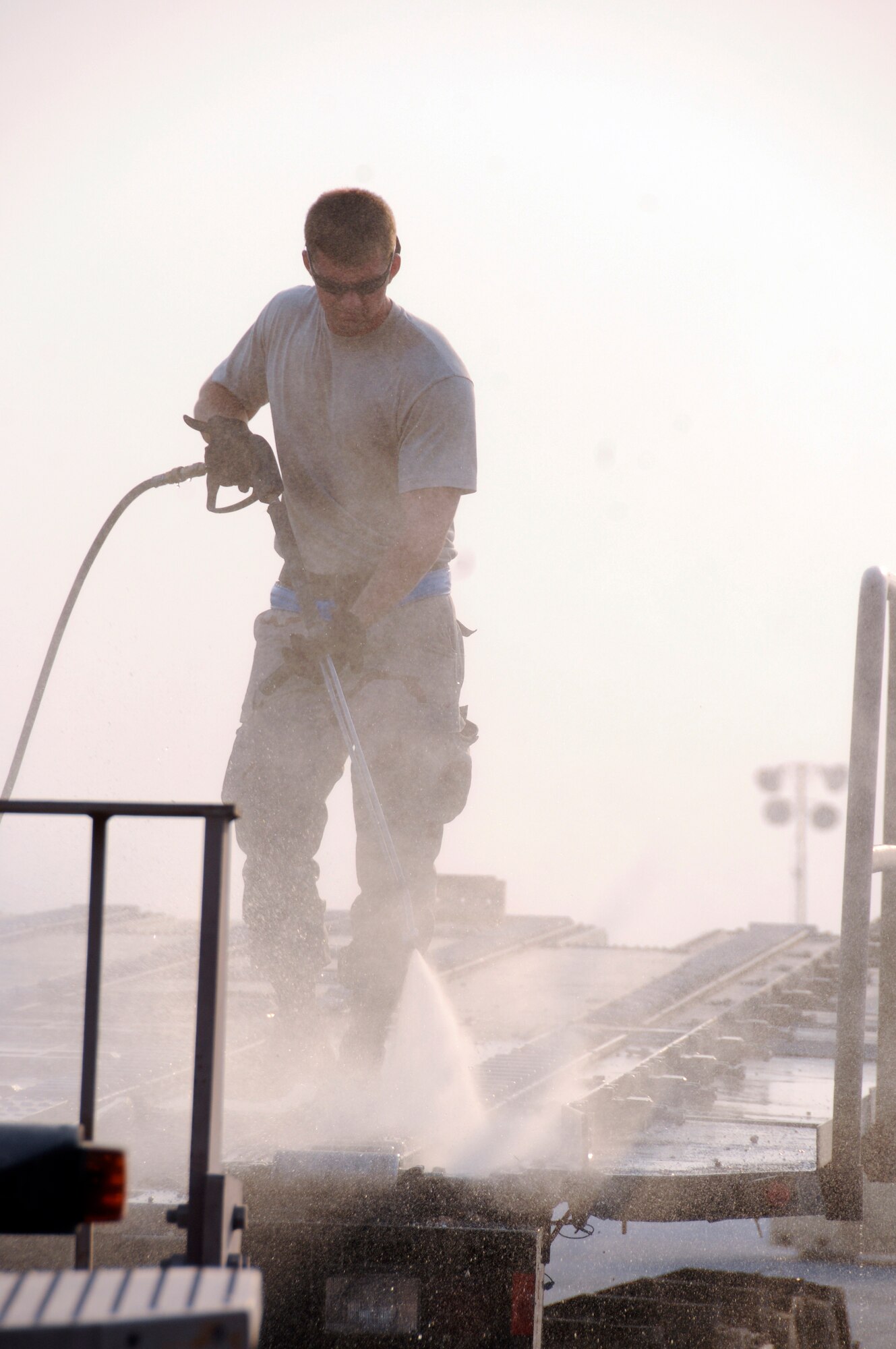 Staff Sgt. Darryl Leytham, 8th Expeditionary Air Mobility Squadron, power washes caked dirt from the top of a 60K loader Aug. 27, 2008 at an undisclosed location in Southwest Asia.  The dirt is being cleaned off the loader to prepare it for scheduled maintenance. Sergeant Leytham, a native of Mobile, Ala., is deployed from Eglin Air Force Base, Fla., in support of Operations Iraqi and Enduring Freedom and Joint Task Force-Horn of Africa.  (U.S. Air Force photo by Tech. Sgt. Michael Boquette/Released)