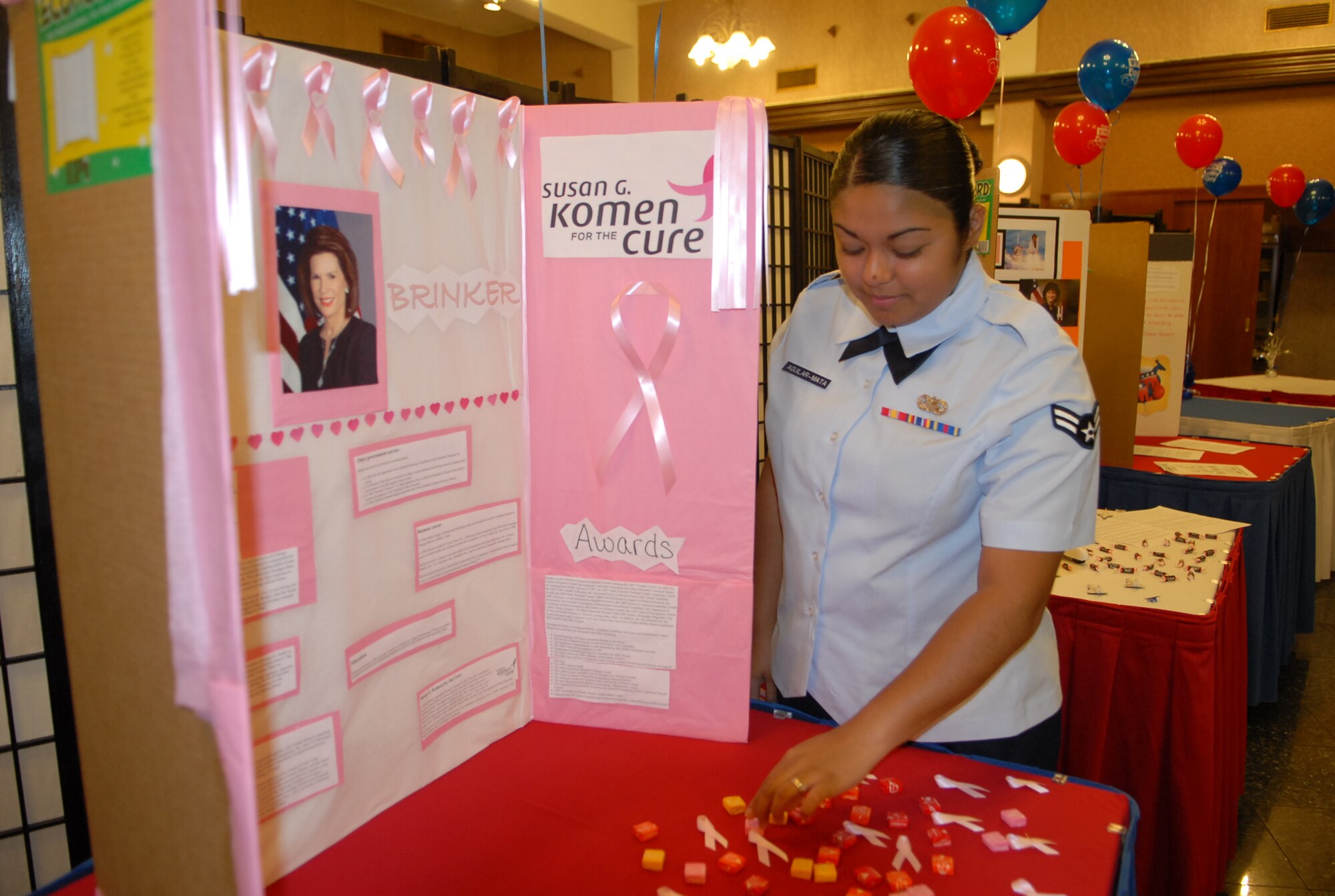 Airman 1st Class Crystal Aguilar-Mata, 18th Wing Judge Advocate office, sets up her station for the Women's Equality Day exhibit on Aug. 26 which is the anniversary of women receiving the right to vote and is recognized in the United States as Women's Equality Day.  (U.S. Air Force Photo/Staff Sgt Angelique Perez) 