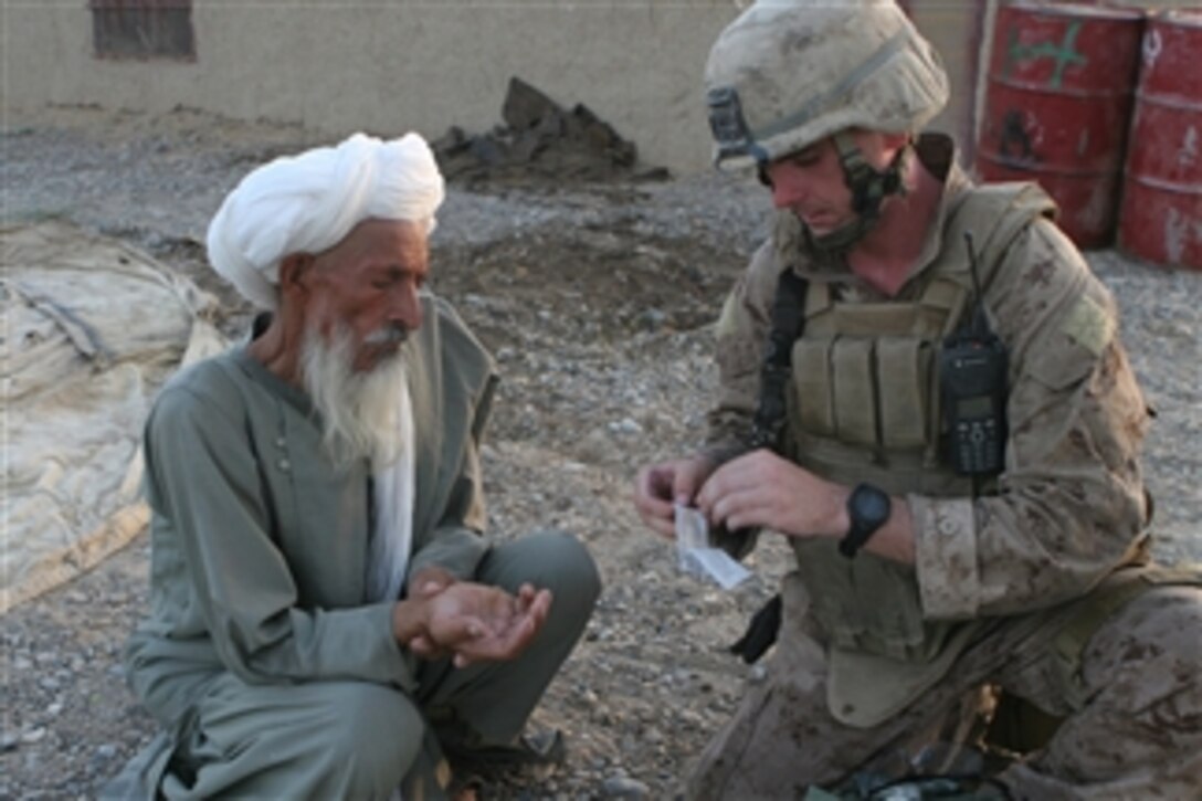 A U.S. Marine provides first aid care for an Afghan man during a patrol through the Helmand province in southern Afghanistan on Aug. 3, 2008.  The Marine is assigned to Alpha Company, Battalion Landing Team, 1st Battalion, 6th Marine Regiment, 24th Marine Expeditionary Unit, NATO International Security Assistance Force.  