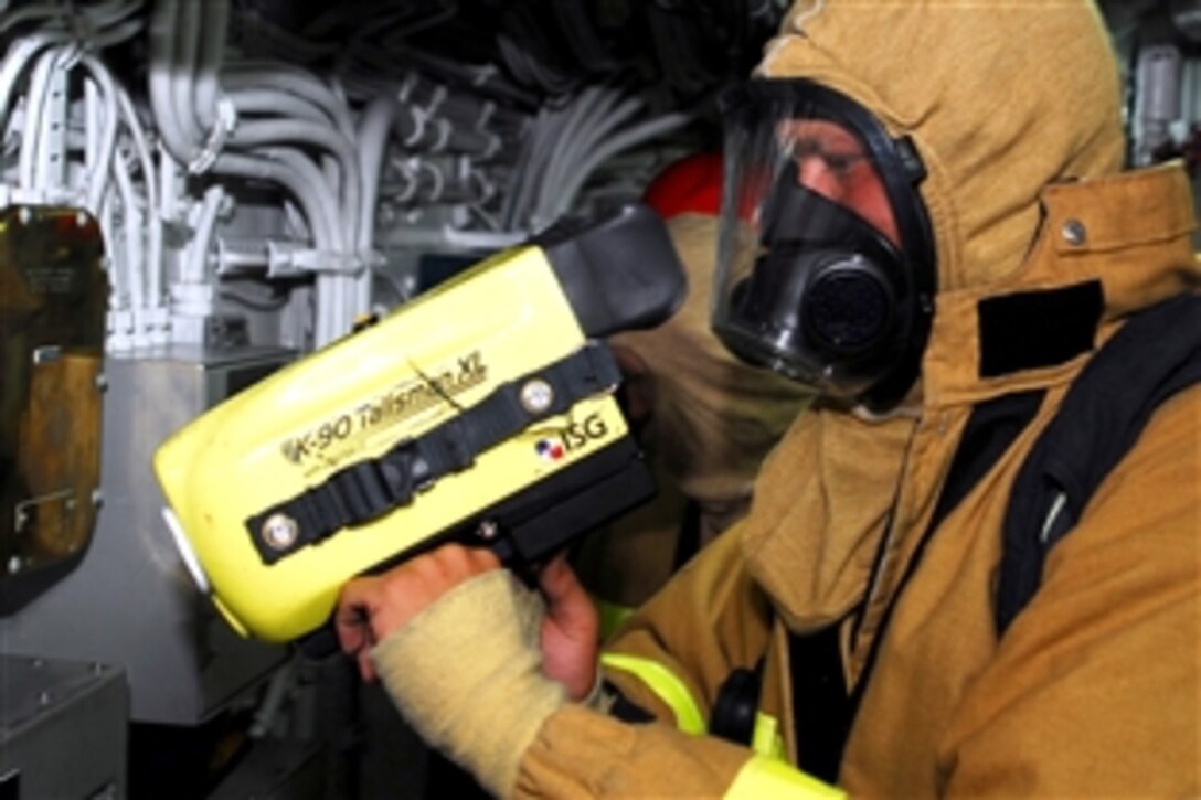 Navy Petty Officer 3rd Class Wes Akin performs an equipment test on the naval firefighting thermal imager while suiting up for a main space fire drill aboard the mine countermeasures ship USS Guardian in Sasebo, Japan, Aug. 27, 2008. Guardian is undergoing an engineering specific, unit-level training assessment, evaluated by assessors from Afloat Training Group Western Pacific.