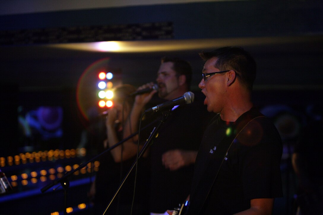The three vocalists of Deep 6, (from right to left) Dan Claire, Joe Becker and Sabrina Smith, perform for the first time to a live audience at a local bowling alley Aug. 29.  The members of the band are all somehow related to the Marine Corps and got together in August through mutual friends just to have some fun.