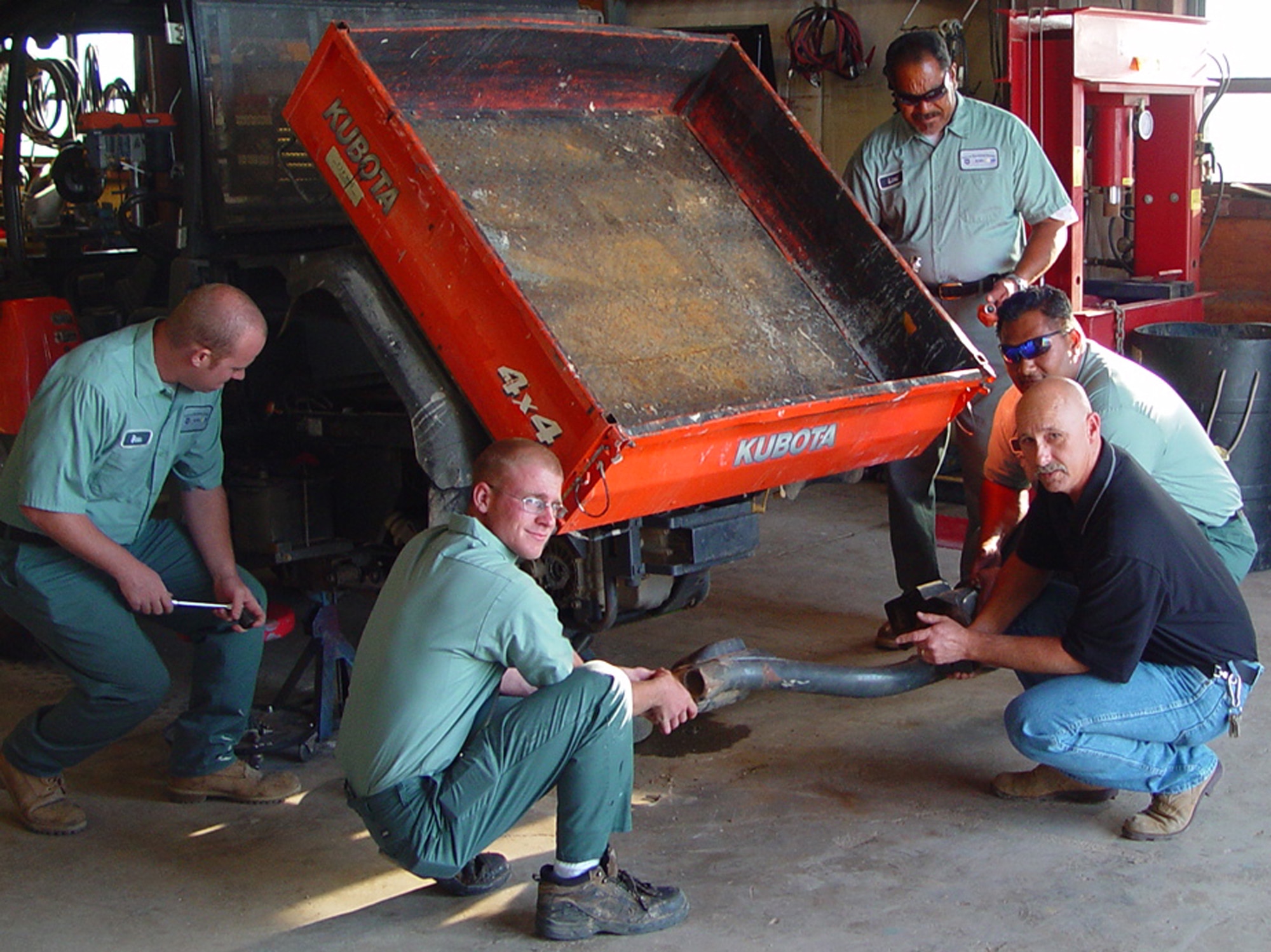 Mr. Bryan Baker, an onsite government employee and certified mechanic, and the range staff performing vehicle repairs. (U.S. Air Force Photo)