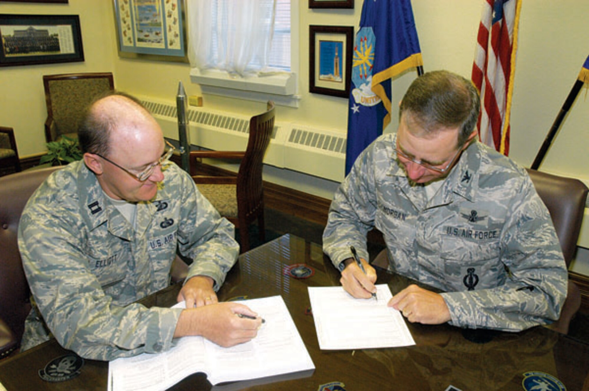 Capt. Garry Elliott, 90th Comptroller Squadron, and Col. Mike Morgan, 90th Missile Wing commander, register to vote.