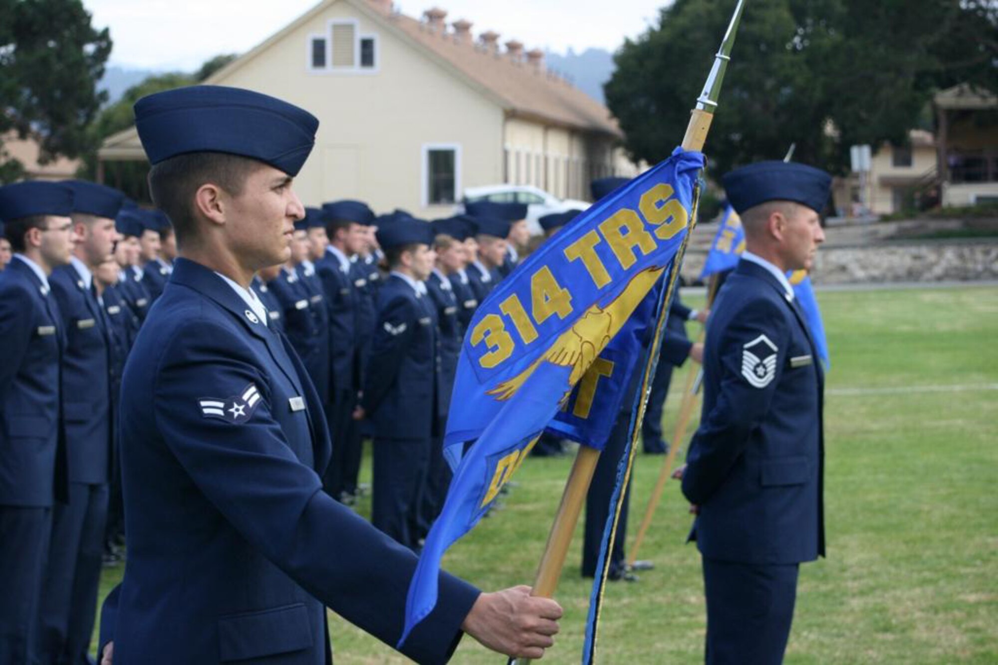 Master Sergeant Daniel Campbell (right) and Airman 1st Class Byron Verdugo (guidon bearer) lead their flight in the 314th Training Squadron formation during the unit activation ceremony Aug. 5 at the Presidio of Monterey, Calif. (U.S. Air Force photo)