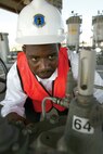8/25/2008 - Jerry Vesey, 37th Civil Engineer Squadron, inspects the settings on a non-surge check valve, which is part of a system that delivers fuel to aircraft flying in to and out of the Kelly Field Annex. Mr. Vessey was recently named Air Education and Training Command's 2009 Black Engineer of the Year in the most promising engineer or scientist category. (USAF photo Robbin Cresswell) 