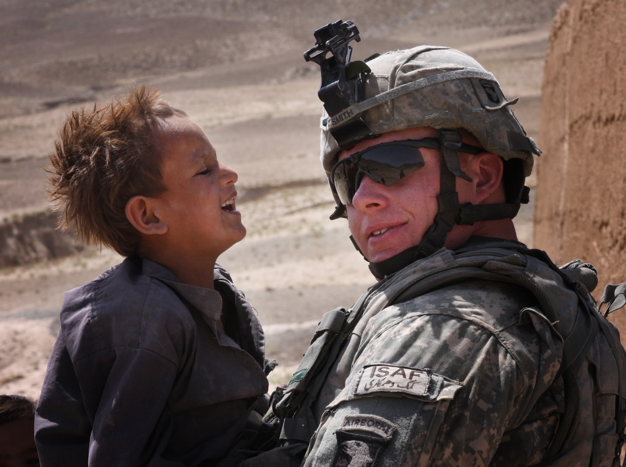 BAGRAM AIR FIELD, Afghanistan -- A child from Shawo Katay Village laughs at Sgt. Jeremy Smith of Alpha Company.  Task Force Gladiator distributed school supplies to Shawo Katay, Hasanzi and Jurghati in Kohi Sofi District, Parwan province, on Aug. 26. In addition to delivering school supplies, Soldiers fostered relations with local villagers. (Courtesy photo)
