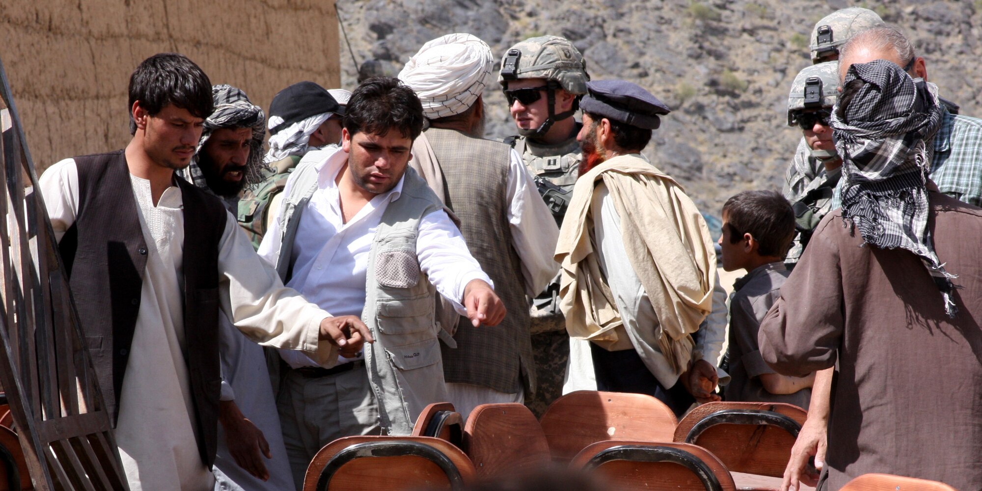 BAGRAM AIR FIELD, Afghanistan -- A local contractor from a contracted construction and supply company counts desks with villagers in Kohi Sofi District, Parwan province, as Task Force Gladiator Soldiers distribute school supplies on Aug. 26.  The village received 75 desks, 10 chalk boards and 150 sets of basic school materials. (Courtesy photo)