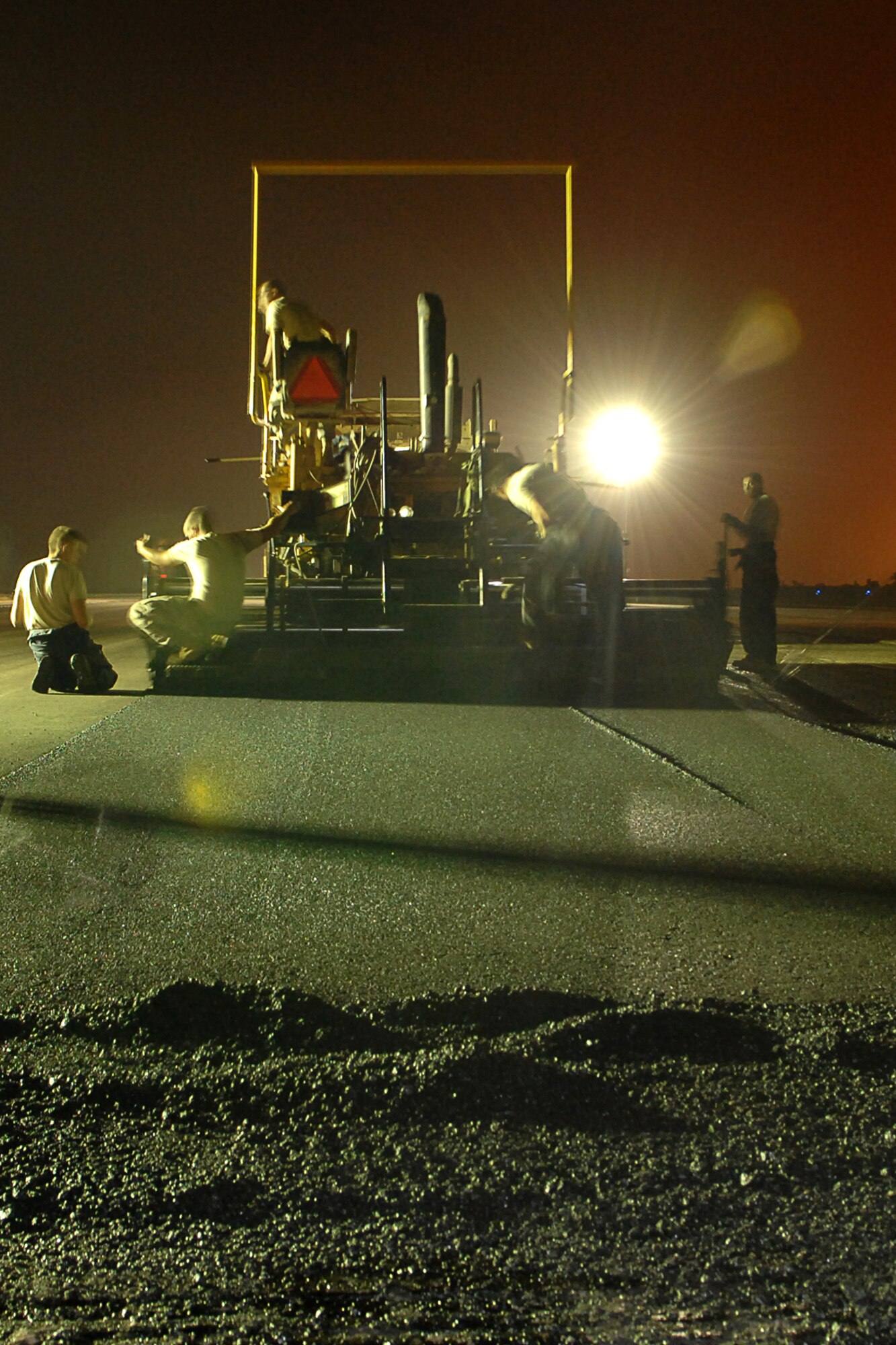 KIRKUK REGIONAL AIR BASE, Iraq -- Red Horse Airmen begin to lay asphalt on the runway here Aug 28.  The team is made up of Airmen from around the Air Force and are here for approximately 90 days to repair the runway. The project will help reduce FOD and eliminate cracks and potholes of the old surface.  They've completed the milling of 1.3 million square feet of runway and are in the process of laying down 38,000 tons of asphalt.  The job is due to be completed Oct. 1. (U.S Air Force photo/ Senior Airman Randi Flaugh)

