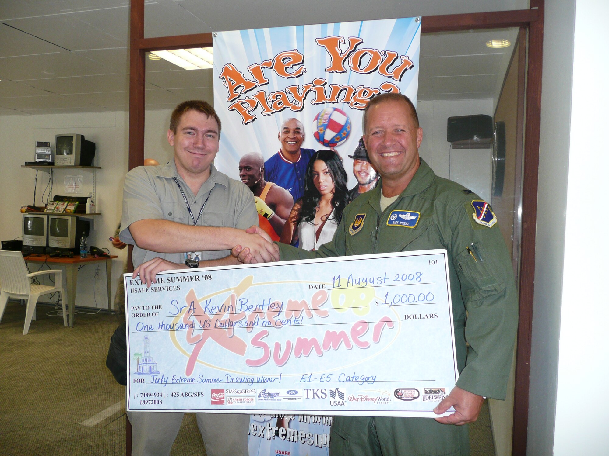 Senior Airman Kevin Bentley, 425th Air Base Group, Izmir, accepts a $1,000 check from Colonel Richard Robel, 425th Air Base Group commander, Aug. 11. Airman Bently earned the check by entering Extreme Summer points into the online competition. (curtesy photo)
