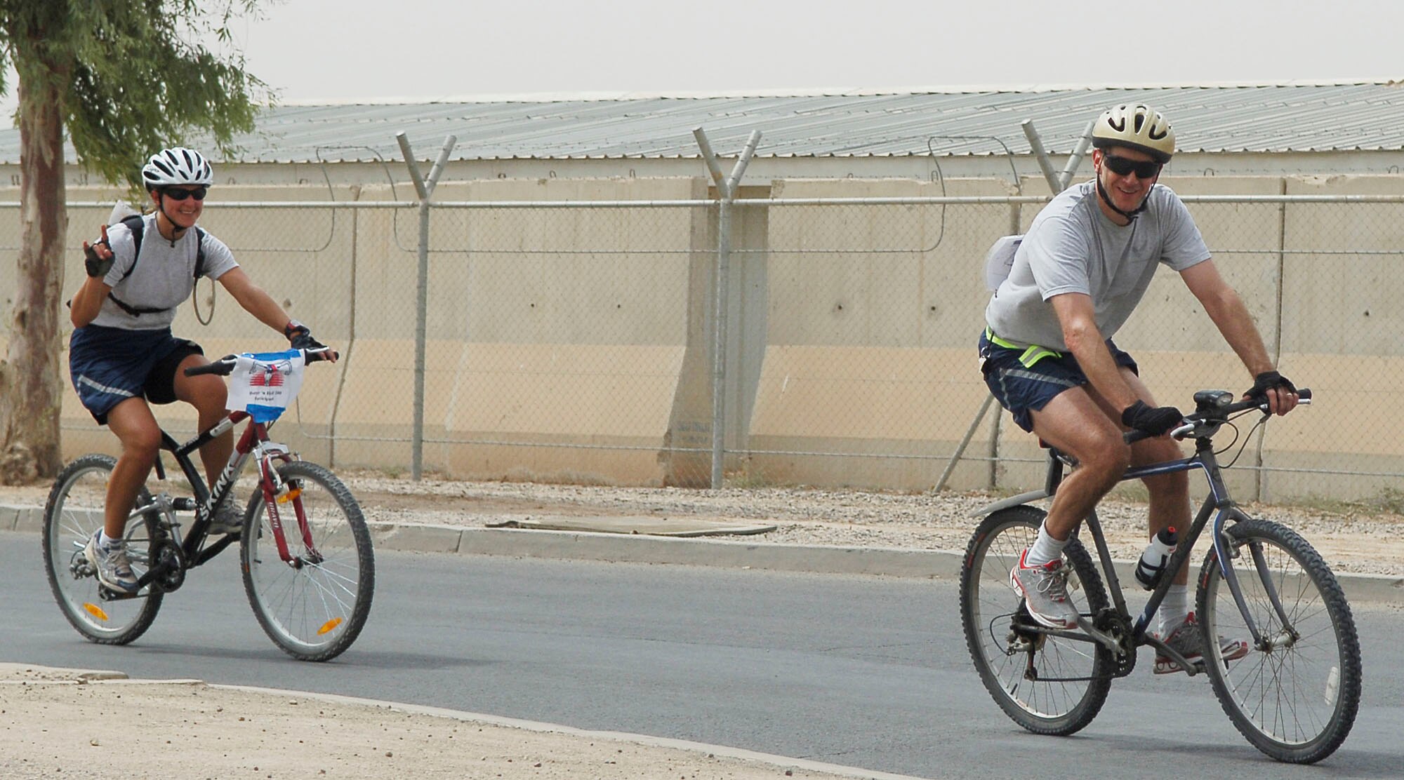 JOINT BASE BALAD, Iraq -- Lt. Cols. Kristen Beals and Randy Green take the second-to-last turn before completing the outdoor segment of their Hotter'N Hell Hundred endurance race Aug. 23. Beals and Green each traversed more than 100 miles on bicycles during the remote version of an event based in Wichita Falls, Texas. Both officers are assigned to the 332nd Expeditionary Medical Group here: Beals is a general surgeon deployed from Royal Air Force Lakenheath, England, and Green is a physical therapist deployed from Davis-Monthan Air Force Base, Ariz. (U.S. Air Force photo/Senior Airman Thomas Trower)