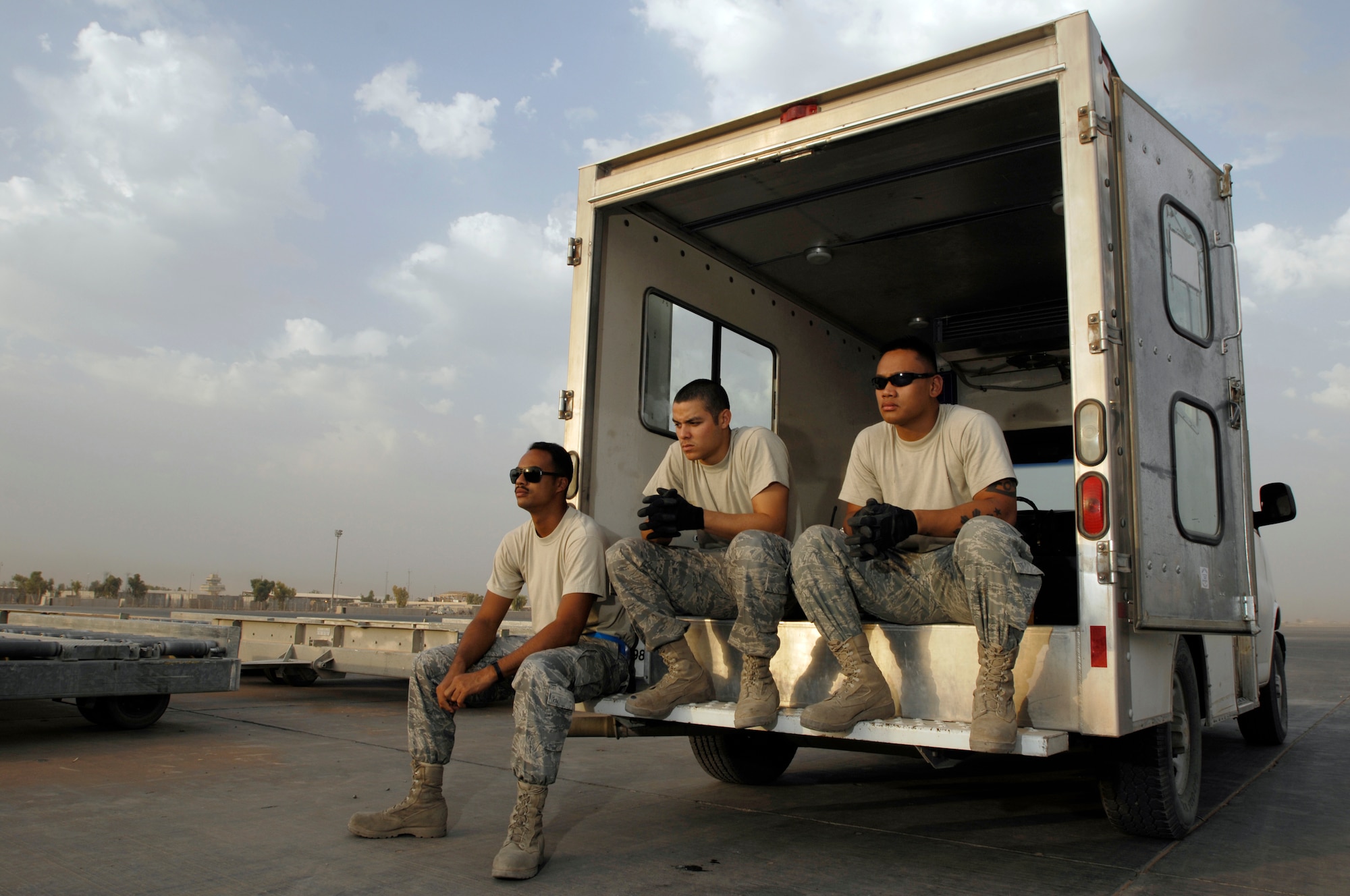 JOINT BASE BALAD, Iraq -- Airmen 1st Class Shane Costa and Dennis Gaxiola and Senior Airman Derek Dumlao wait for an aircraft to arrive here shortly after dawn Aug. 24. All three Airmen completed a new Air Force Reserve seasoning training program prior to deploying here. The program allows Airmen to voluntarily remain on active duty for upgrade training, finishing it in three months instead of 14 to 16 months. Dumlao, Gaxiola and Costa, aerial porters with the 332nd Expeditionary Logistics Readiness Squadron here, are deployed from the 624th Regional Support Group at Hickam Air Force Base, Hawaii. All three Airmen graduated from Leilehua High School in Wahiawa, Hawaii, in 2004. (U.S. Air Force photo/Airman 1st Class Jason Epley)