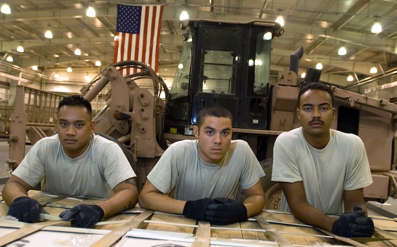 JOINT BASE BALAD, Iraq -- (from left to right) Senior Airman Derek Dumlao, Airman 1st Class Dennis Gaxiola and Airman 1st Class Shane Costa stand before a built palette here Aug. 24. All three Airmen completed a new Air Force Reserve seasoning training program prior to deploying here. The program allows Airmen to voluntarily remain on active duty for upgrade training, finishing it in three months instead of 14 to 16 months. Dumlao, Gaxiola and Costa, aerial porters with the 332nd Expeditionary Logistics Readiness Squadron here, are deployed from the 624th Regional Support Group at Hickam Air Force Base, Hawaii. All three Airmen graduated from Leilehua High School in Wahiawa, Hawaii, in 2004. (U.S. Air Force photo/Airman 1st Class Jason Epley)