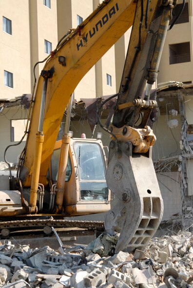 With two brand new, multi-story dormitories open, workers tear down and dispose of building 614 at Kunsan Air Base. The demolition is a part of a base wide quality of life improvement initiative to include construction of new dormitories. (U.S. Air Force photo/Staff Sgt. Jason Colbert)