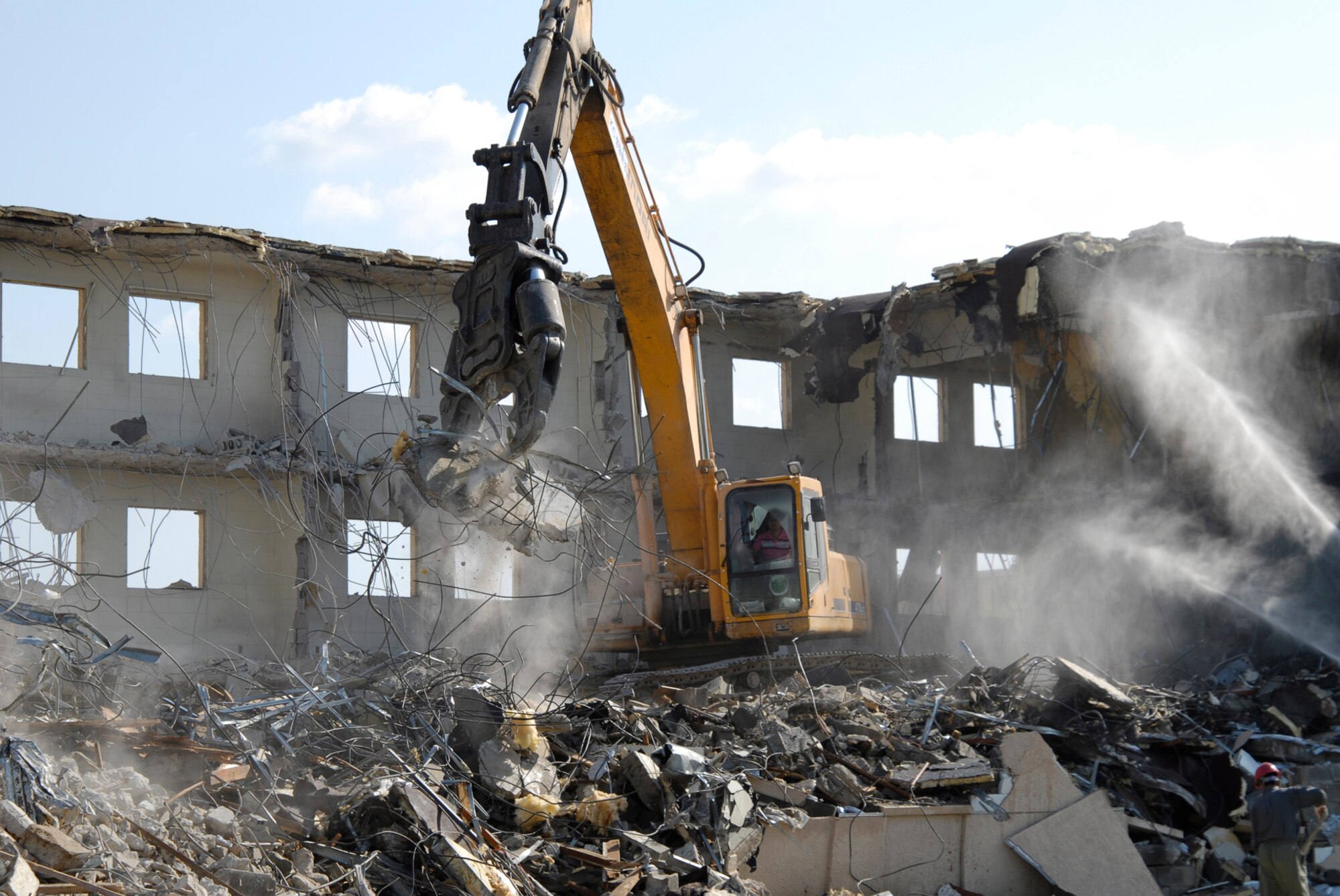 With two brand new, multi-story dormitories open, workers tear down and dispose of building 614 at Kunsan Air Base. The demolition is a part of a base wide quality of life improvement initiative to include construction of new dormitories. (U.S. Air Force photo/Staff Sgt. Jason Colbert)