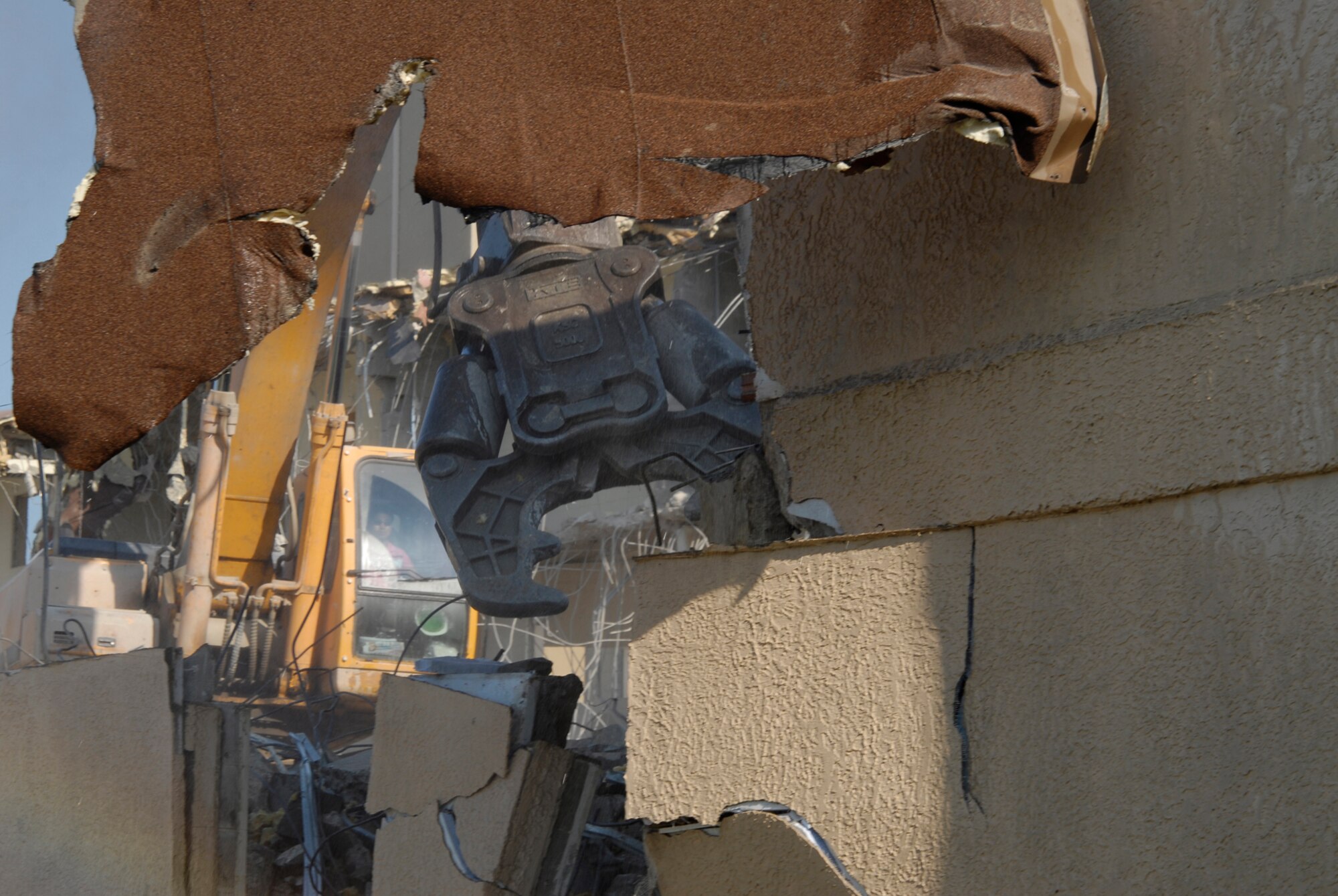 With two brand new, multi-story dormitories open, workers tear down and dispose of building 614 at Kunsan Air Base. The demolition is a part of a base wide quality of life improvement initiative to include construction of new dormitories. (U.S. Air Force photo/Staff Sgt. Jason Colbert)