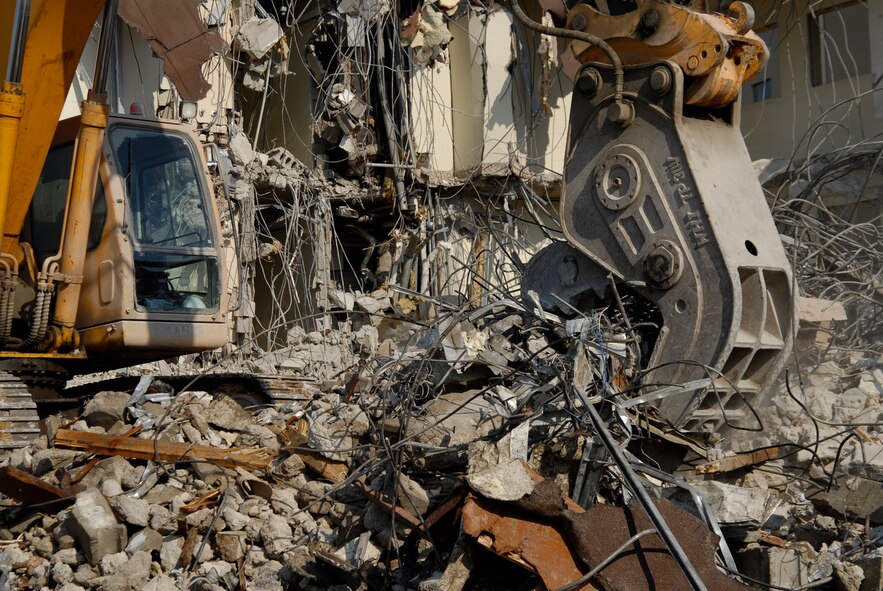 With two brand new, multi-story dormitories open, workers tear down and dispose of building 614 at Kunsan Air Base. The demolition is a part of a base wide quality of life improvement initiative to include construction of new dormitories. (U.S. Air Force photo/Staff Sgt. Jason Colbert)