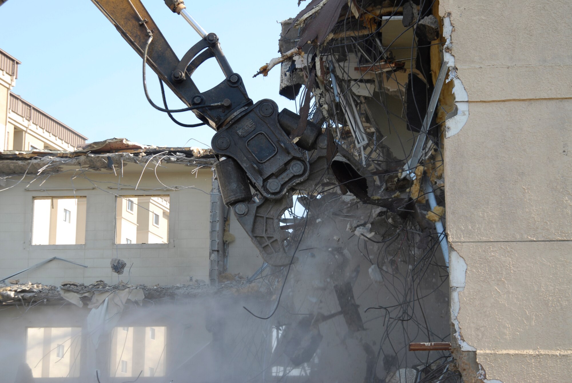 With two brand new, multi-story dormitories open, workers tear down and dispose of building 614 at Kunsan Air Base. The demolition is a part of a base wide quality of life improvement initiative to include construction of new dormitories. (U.S. Air Force photo/Staff Sgt. Jason Colbert)