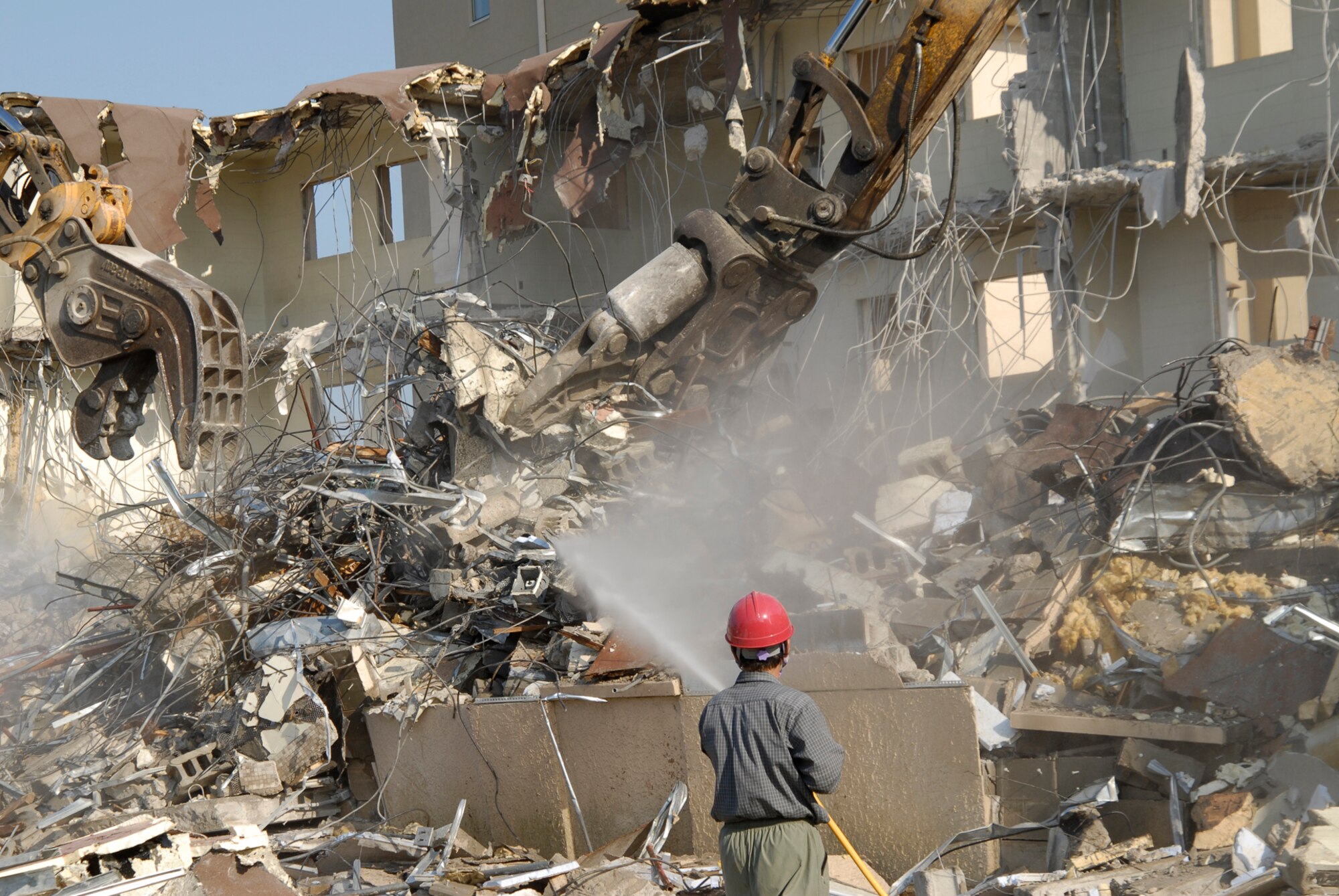 With two brand new, multi-story dormitories open, workers tear down and dispose of building 614 at Kunsan Air Base. The demolition is a part of a base wide quality of life improvement initiative to include construction of new dormitories. (U.S. Air Force photo/Staff Sgt. Jason Colbert)