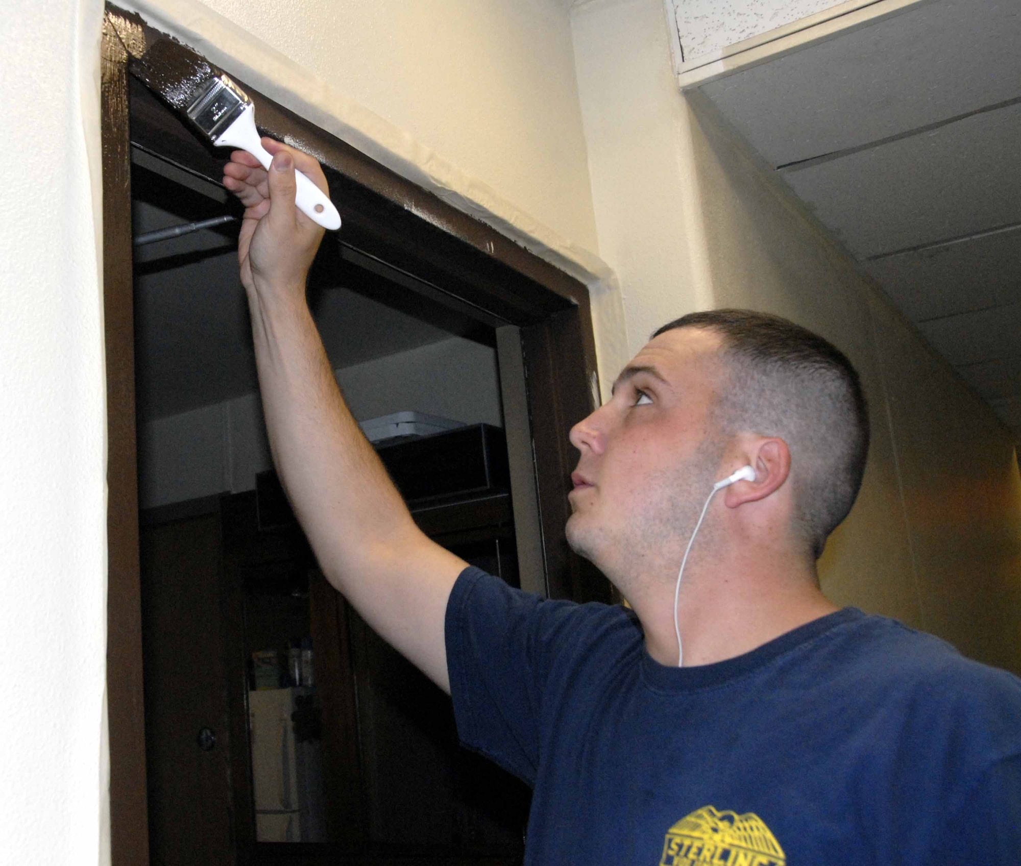 OSAN AIR BASE, Republic of Korea -- Airman 1st Class Corey Lockhart paints the trim of his dorm room Aug. 23. Dorm residents, supervisors, first sergeants, squadron and wing leadership spent the day cleaning up and repainting the dormitory. The project is part of a long renovation process initiated by Dorm 1436 residents to instill a sense of ownership in their home. Airman Lockhart is assigned to the 51st Security Forces Squadron. (U.S. Air Force photo/Staff Sgt. Candy Knight)