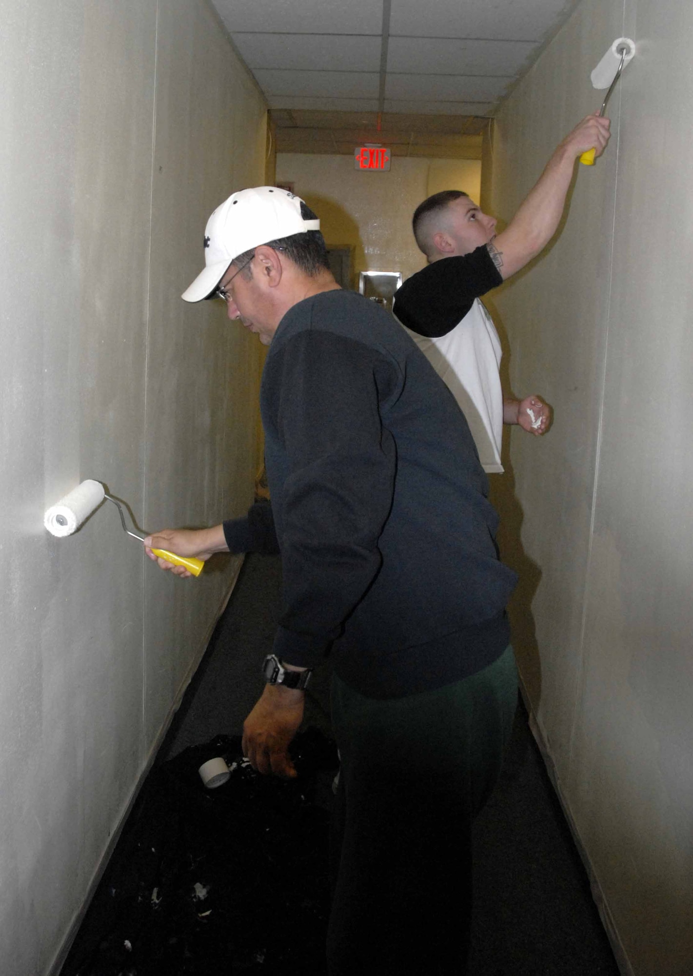 OSAN AIR BASE, Republic of Korea -- Col. Roland Van Deventer, 51st Mission Support Group commander, (foreground), and Airman 1st Class Brandon Kelly, 51st Security Forces Squadron, paint Dorm 1436 hallway walls Aug. 23, as part of the dorm residents self-imposed dorm renovation project. (U.S. Air Force photo/Staff Sgt. Candy Knight)