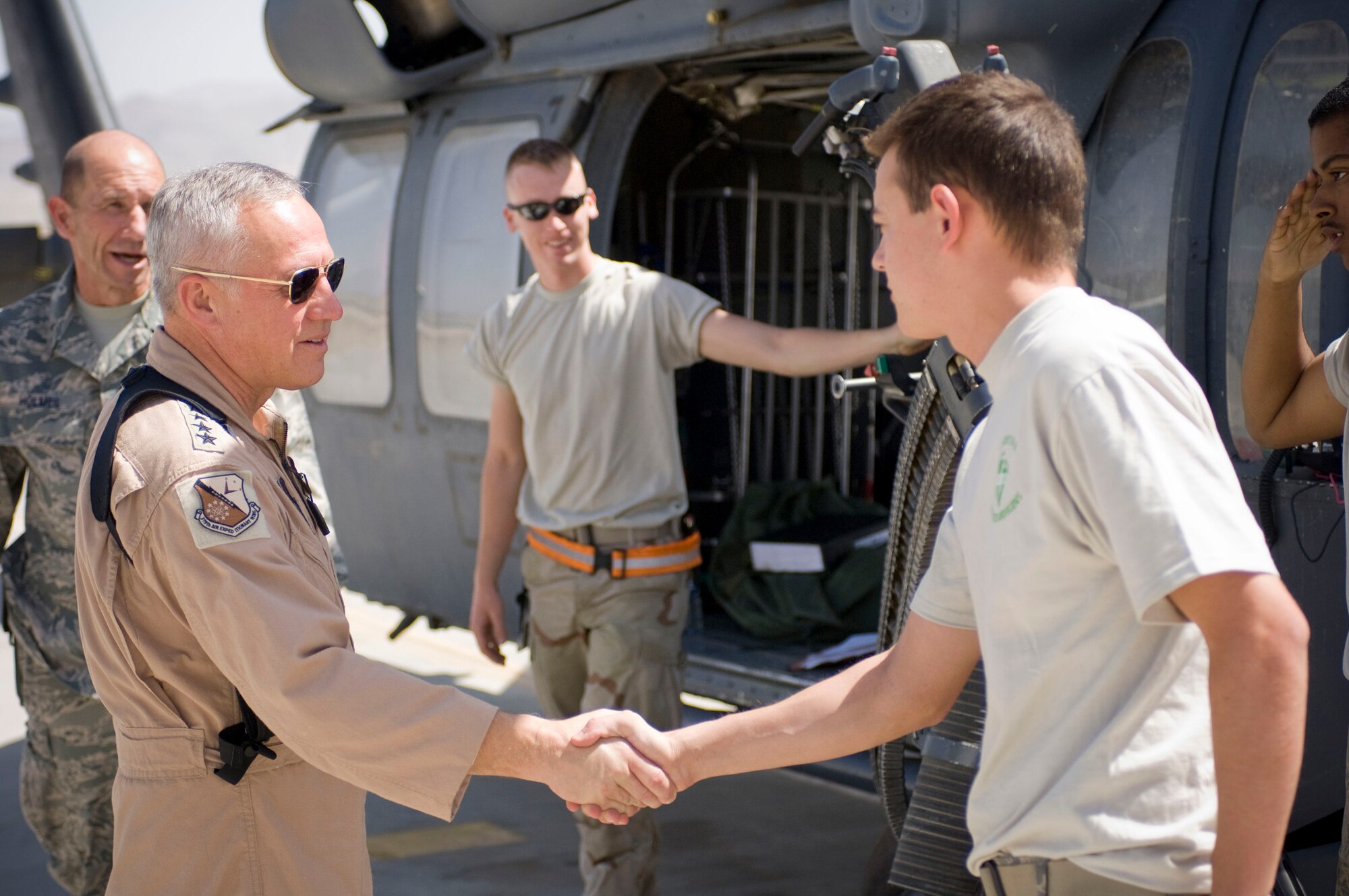 BAGRAM AIR FIELD, Afghanistan -- General Bruce Carlson, Air Force Materiel Command commander, shakes hands with Airman 1st Class Bryan Murphy, 33rd Expeditionary Helecopter Maintenance Unit guidance and control technician, here on August 22, 2208. General Carlson visited with the helicopter maintainers during his visit to Bagram Air Field. Airman Murphy is deployed from the 33rd Helicopter Maintenance Unit, Kadena Air Base, Japan, and hails from Phoenix, Ariz. (U.S. Air Force photo by Staff Sgt. Samuel Morse/Released)
