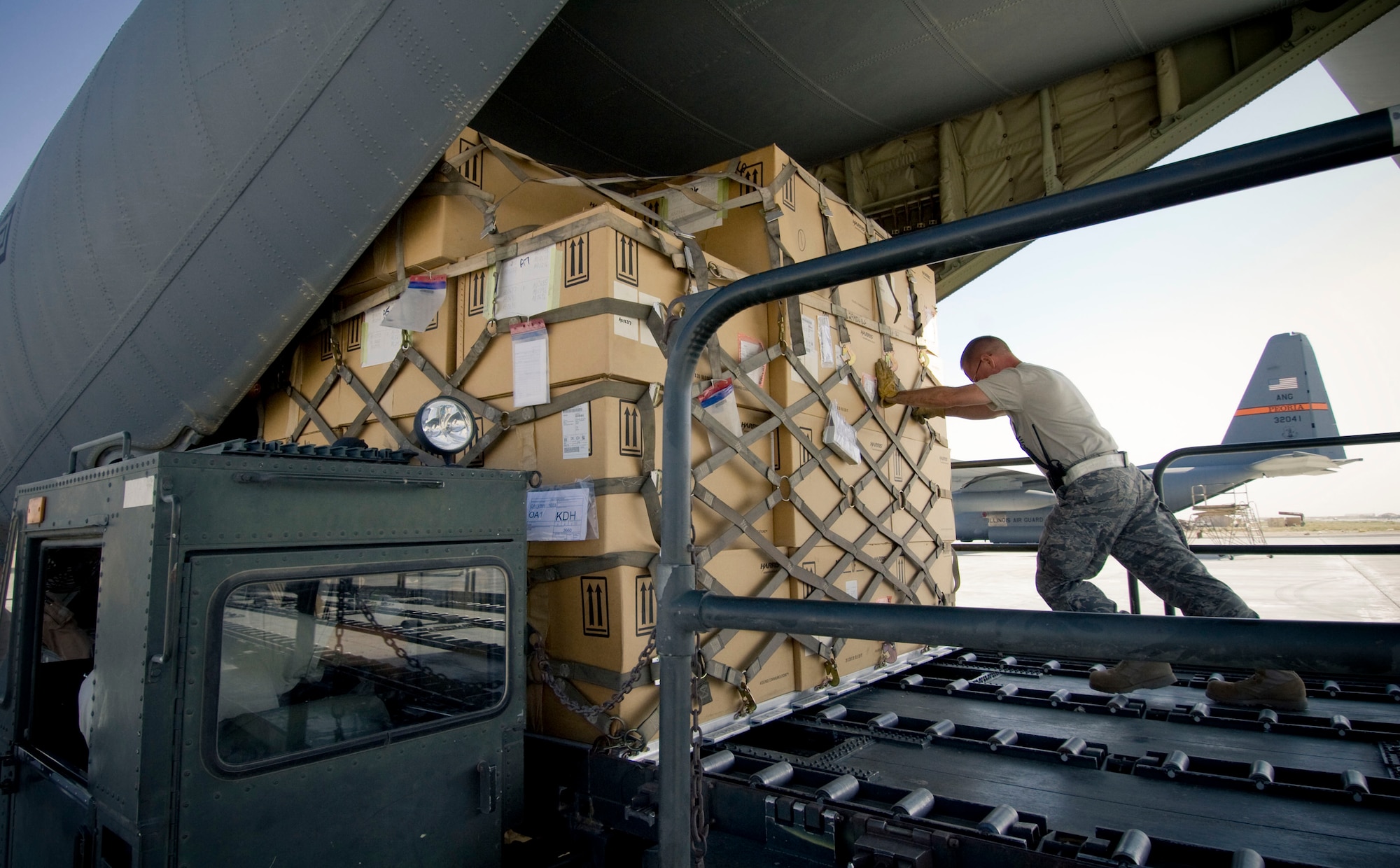 BAGRAM AIR FIELD, Afghanistan -- A loadmaster guides a fully-loaded aircraft pallet onto a C-130J Hercules here on August 28, 2008. The C-130 fleet provides crucial airlift missions transporting supplies to locations ranging from fully-established bases to dirt drop zones in the wilderness of Afghanistan. (U.S. Air Force photo by Staff Sgt. Samuel Morse/Released)
