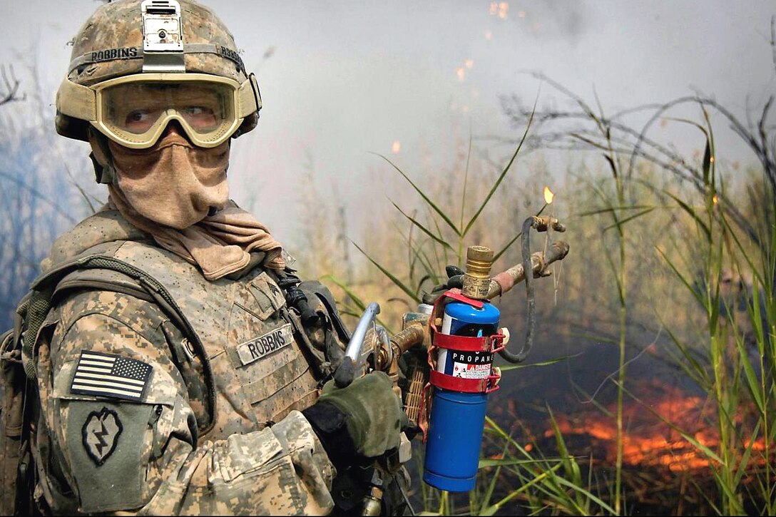 U.S. Army Sgt. Joshua Robbins uses a flame thrower to burn down reeds that have reduced visibility of the surrounding area to a nearby Iraqi Army outpost near Tarmiyah, Iraq, Aug. 26, 2008. Robbins is assigned to the 25th Infantry Division's 66th Engineer Company.