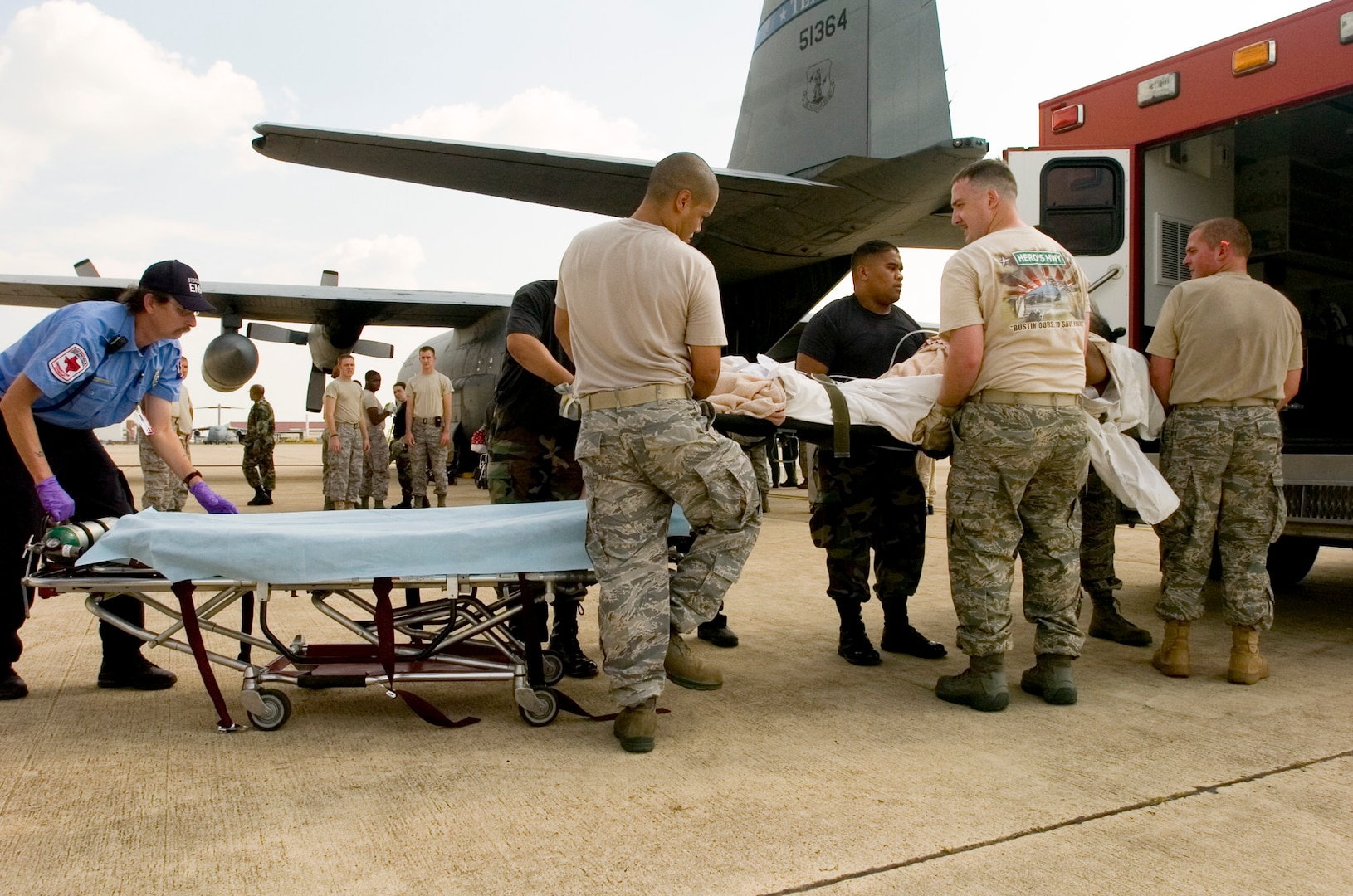 Airmen lift a woman on a litter into an ambulance on the flight line at the former Kelly Air Force Base, Texas, Aug. 30. The Texas Air National Guard C-130 brought 23 evacuees from Beaumont, Texas, to San Antonio before Hurricane Gustav reached the Gulf Coast.  Members from the 37th Training Wing and 59th Medical Wing at Lackland AFB, Texas, and from the Air National Guard and Air Force Reserve help in the hurricane relief efforts as Hurricane Gustav approaches the Gulf Coast. The Port of San Antonio on Kelly AFB is the staging base for FEMA Region 6.  (U.S. Air Force photo/Staff Sgt. Desiree N. Palacios)