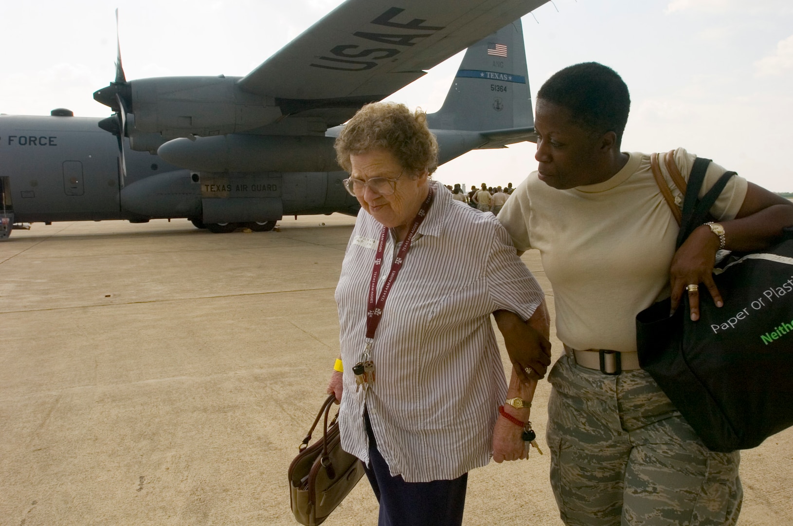 Master Sgt. Robin Williams escorts an elderly woman inside the 37th Operations Support Squadron hangar on the former Kelly Air Force Base, Texas. The Texas Air National Guard C-130 brought 23 evacuees from Beaumont, Texas, to San Antonio before Hurricane Gustav reached the Gulf Coast.  Members from the 37th Training Wing and 59th Medical Wing at Lackland AFB, Texas, and from the Air National Guard and Air Force Reserve help in the hurricane relief efforts as Hurricane Gustav approaches the Gulf Coast. The Port of San Antonio on Kelly AFB is the staging base for FEMA Region 6.  Sergeant Williams is the assistant course supervisor for the Phase II Aerospace Medical Service Apprentice Course for the 59th Training Squadron Lackland AFB, Texas. (U.S. Air Force photo/Staff Sgt. Desiree N. Palacios)