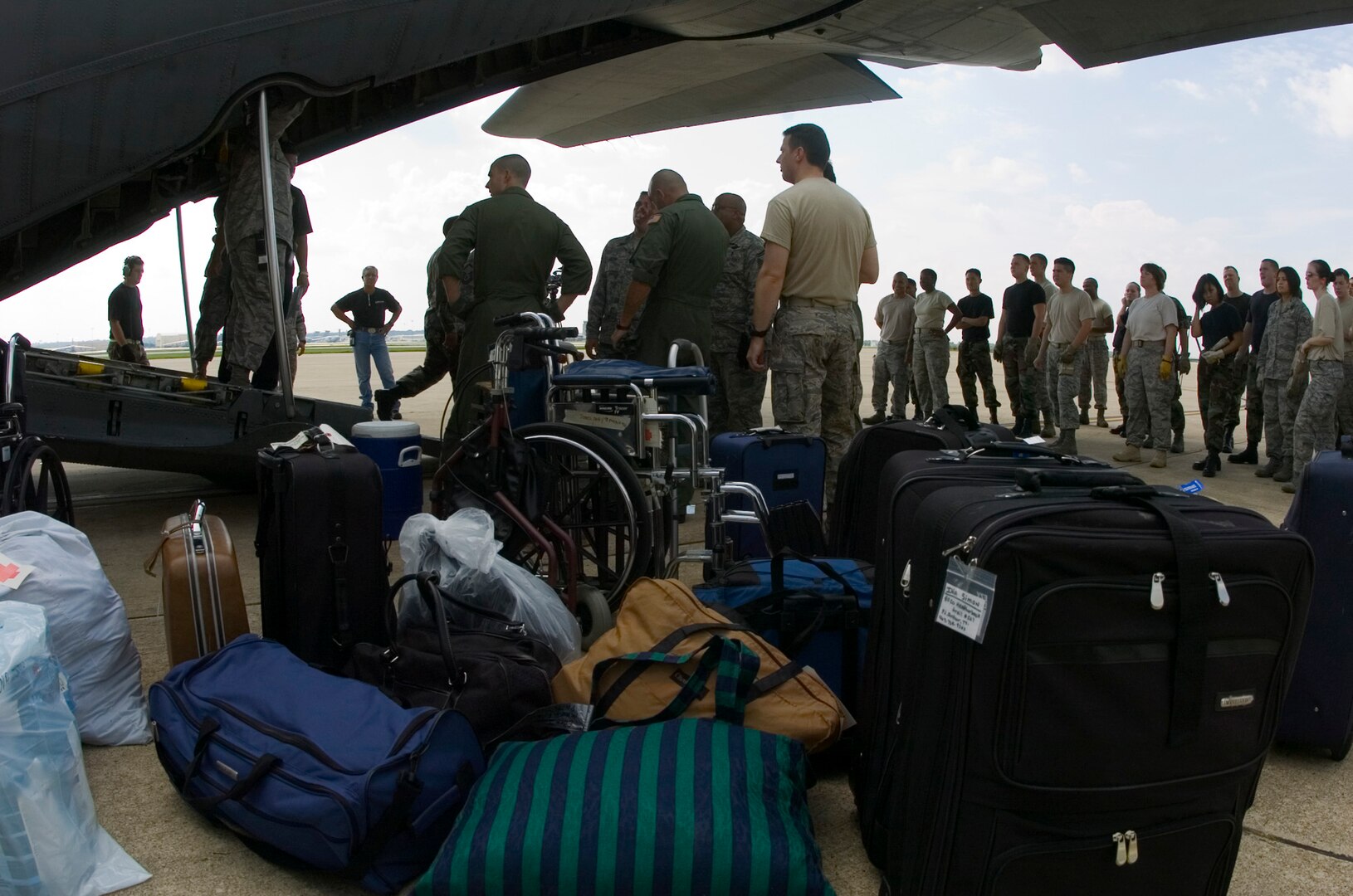 Luggage is unloaded from a Texas Air National Guard C-130 Hercules carrying 23 evacuees from Beaumont, Texas, Aug. 30 to the former Kelly Air Force Base, Texas.  Members from the 37th Training Wing and 59th Medical Wing at Lackland AFB, Texas, and from the Air National Guard and Air Force Reserve help in the hurricane relief efforts as Hurricane Gustav approaches the Gulf Coast. The Port of San Antonio on Kelly AFB is the staging base for FEMA Region 6.  (U.S. Air Force photo/Saff Sgt. Desiree N. Palacios)