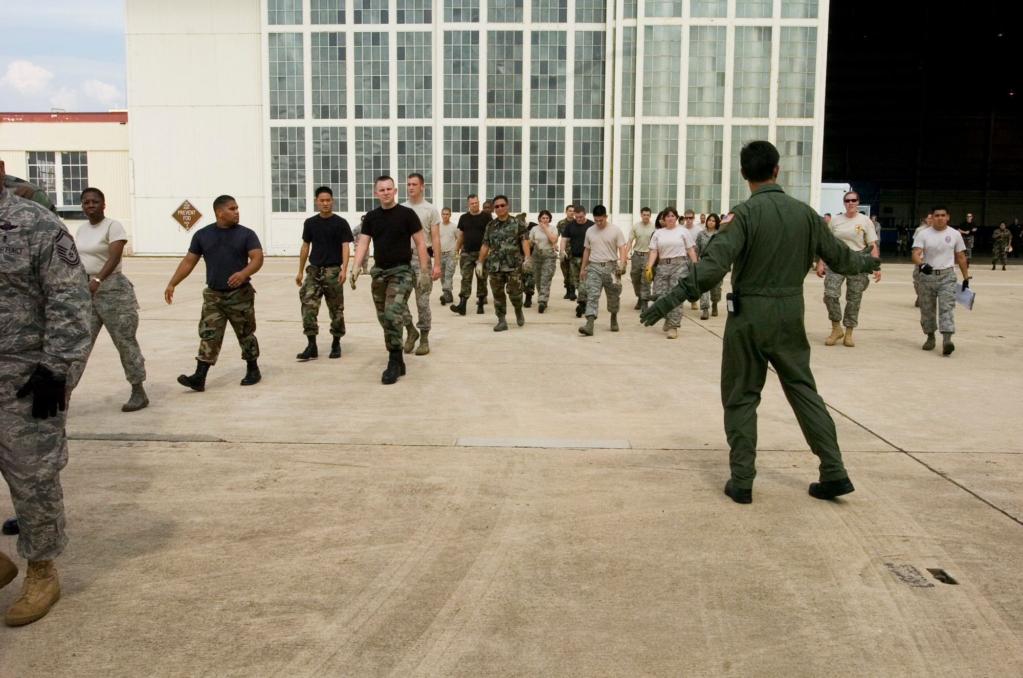 Col. Mark Werner signals Airmen toward a Texas Air National Guard C-130 Hercules carrying 23 evacuees from Beaumont, Texas, that landed Aug. 30 at former Kelly Air Force Base, Texas. Members from the 37th Training Wing and 59th Medical Wing at Lackland AFB, Texas, and from the Air National Guard and Air Force Reserve help in the hurricane relief efforts as Hurricane Gustav approaches the Gulf Coast. The Port of San Antonio on Kelly AFB is the staging base for FEMA Region 6.  Colonel Werner is the commander of the 37th Medical Group based out of Lackland AFB. (U.S. Air Force photo/Staff Sgt. Desiree N. Palacios)