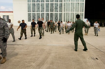 Col. Mark Werner signals Airmen toward a Texas Air National Guard C-130 Hercules carrying 23 evacuees from Beaumont, Texas, that landed Aug. 30 at former Kelly Air Force Base, Texas. Members from the 37th Training Wing and 59th Medical Wing at Lackland AFB, Texas, and from the Air National Guard and Air Force Reserve help in the hurricane relief efforts as Hurricane Gustav approaches the Gulf Coast. The Port of San Antonio on Kelly AFB is the staging base for FEMA Region 6.  Colonel Werner is the commander of the 37th Medical Group based out of Lackland AFB. (U.S. Air Force photo/Staff Sgt. Desiree N. Palacios)