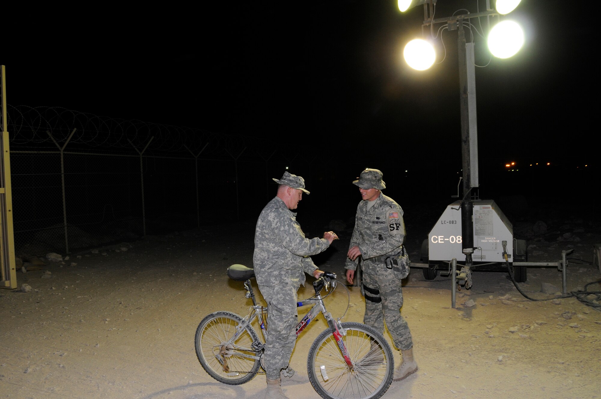 Airman 1st Class Justin Cook, 379th Expeditionary Security Forces Squadron, checks identification of people entering through gate Zulu Seven Alpha Aug. 29, 2008.  The pedestrian gate saves a lot of time and walking/riding for people traveling between work and the housing area at this undisclosed location in Southwest Asia.  Airman Cook hails from Granada, Miss., and is deployed here from Langley Air Force Base, Va., in support of Operations Iraqi and Enduring Freedom and Joint Task Force-Horn of Africa.  (U.S. Air Force photo by Tech. Sgt. Michael Boquette/Released)