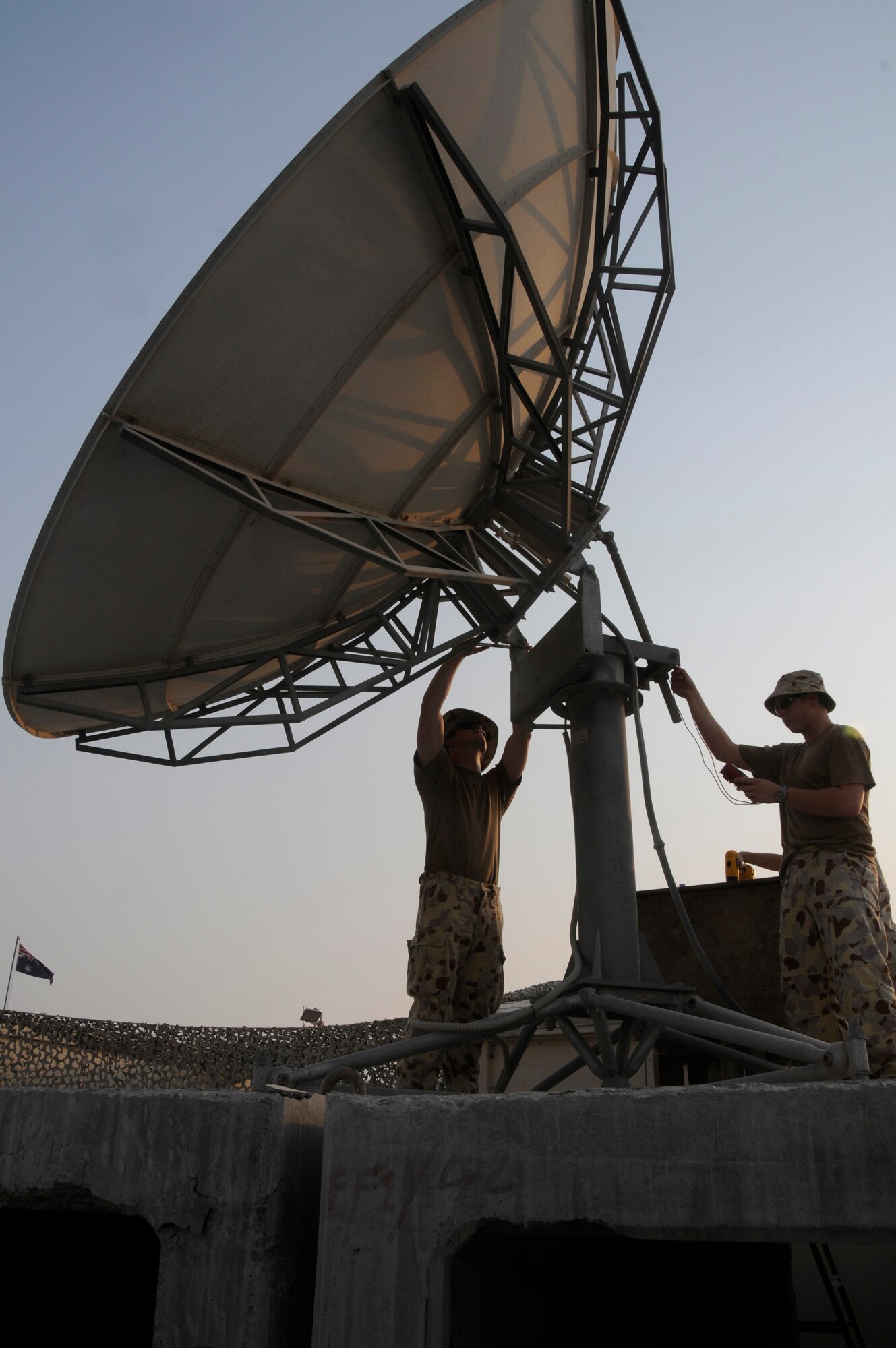 Corporal David Boucaut and Leading Air Craftsman Jamie Sonego, both information technology technicians assigned to the Australian Task Group 633.4, perform daily maintenance on a satellite dish Aug. 28, 2008, at an undisclosed air base in Southwest Asia. They are responsible for providing deployed communications capabilities for the Australian Task Group. Corporal Boucaut is a native of Perth, Australia, and LAC Sonego hails from Byron Bay, Australia.  Both are deployed from the 1st CSS, Australian Air Force, in support of Operations Iraqi and Enduring Freedom and Joint Task Force-Horn of Africa. (U.S. Air Force photo by Staff Sgt. Darnell T. Cannady/Released)