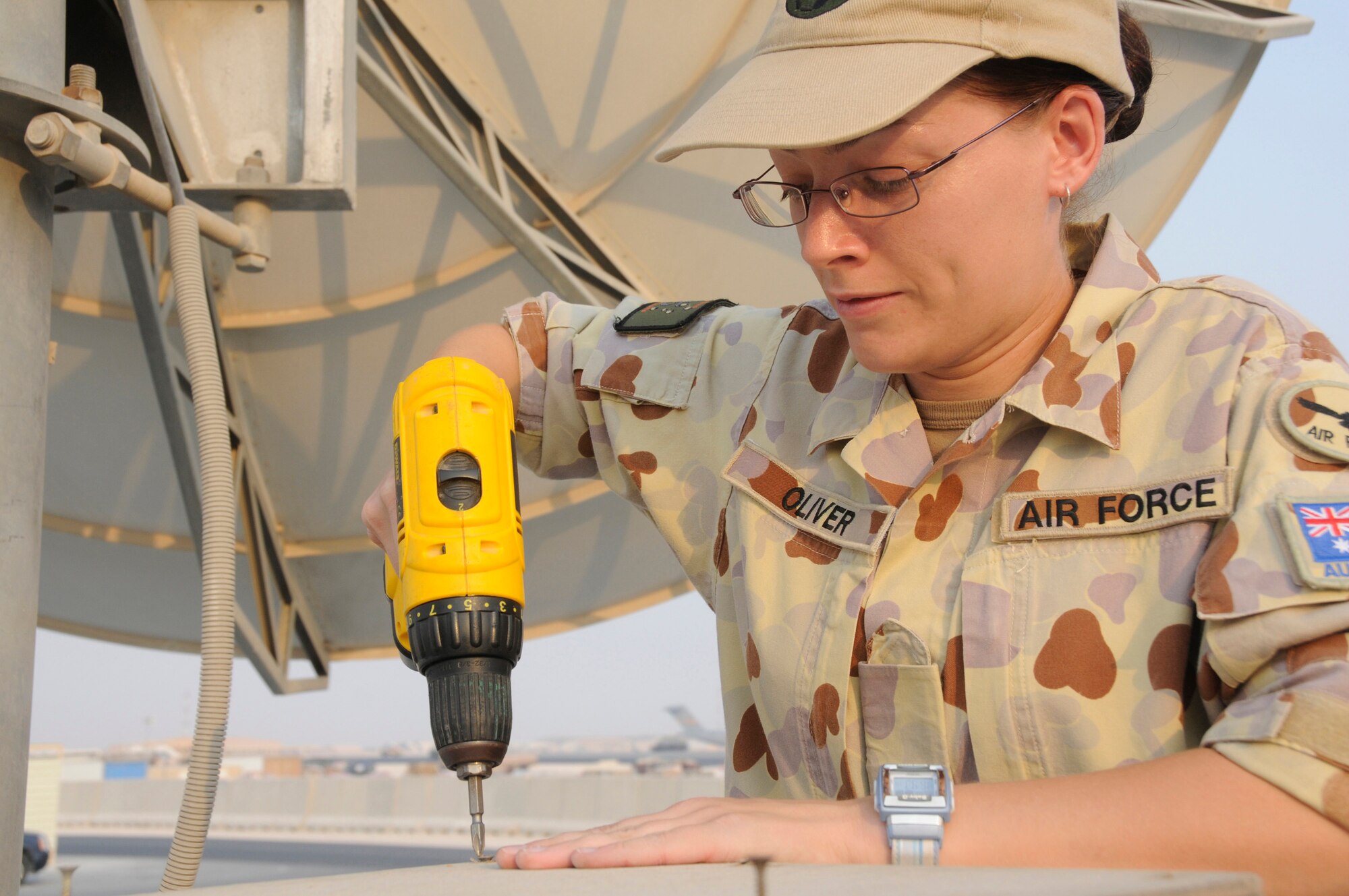 Leading Air Craftsman Woman Lauren Oliver, information technology technician assigned to the Australian Task Group 633.4, uses a drill to close a satellite dish equipment compartment Aug. 28, 2008, at an undisclosed air base in Southwest Asia. She is responsible for providing deployed communications capabilities for the Australian Task Group. LACW Oliver, a native of Brisbane, Australia, is deployed from the 382nd ECSS, Australian Air Force, supporting Operations Iraqi and Enduring Freedom and Joint Task Force-Horn of Africa. (U.S. Air Force photo by Staff Sgt. Darnell T. Cannady/Released)