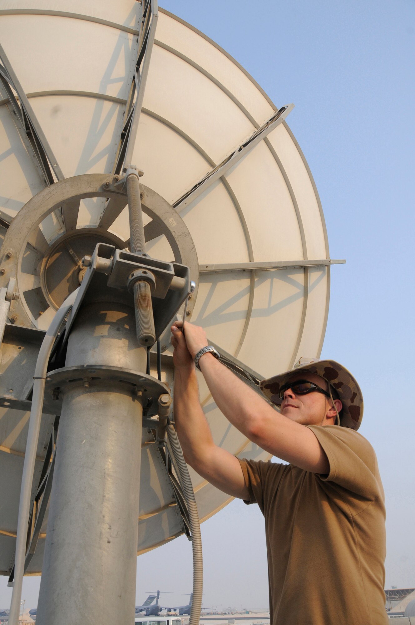 Corporal David Boucaut, information technology technician assigned to the Australian Task Group 633.4, uses a wrench to make adjustments to a satellite dish Aug. 28, 2008, at an undisclosed air base in Southwest Asia. He is responsible for providing deployed communications capabilities for the Australian Task Group. Corporal Boucart, a native of Perth, Australia, is deployed from the 1st CCS, Australian Air Force, in support of Operations Iraqi and Enduring Freedom and Joint Task Force-Horn of Africa. (U.S. Air Force photo by Staff Sgt. Darnell T. Cannady/Released)