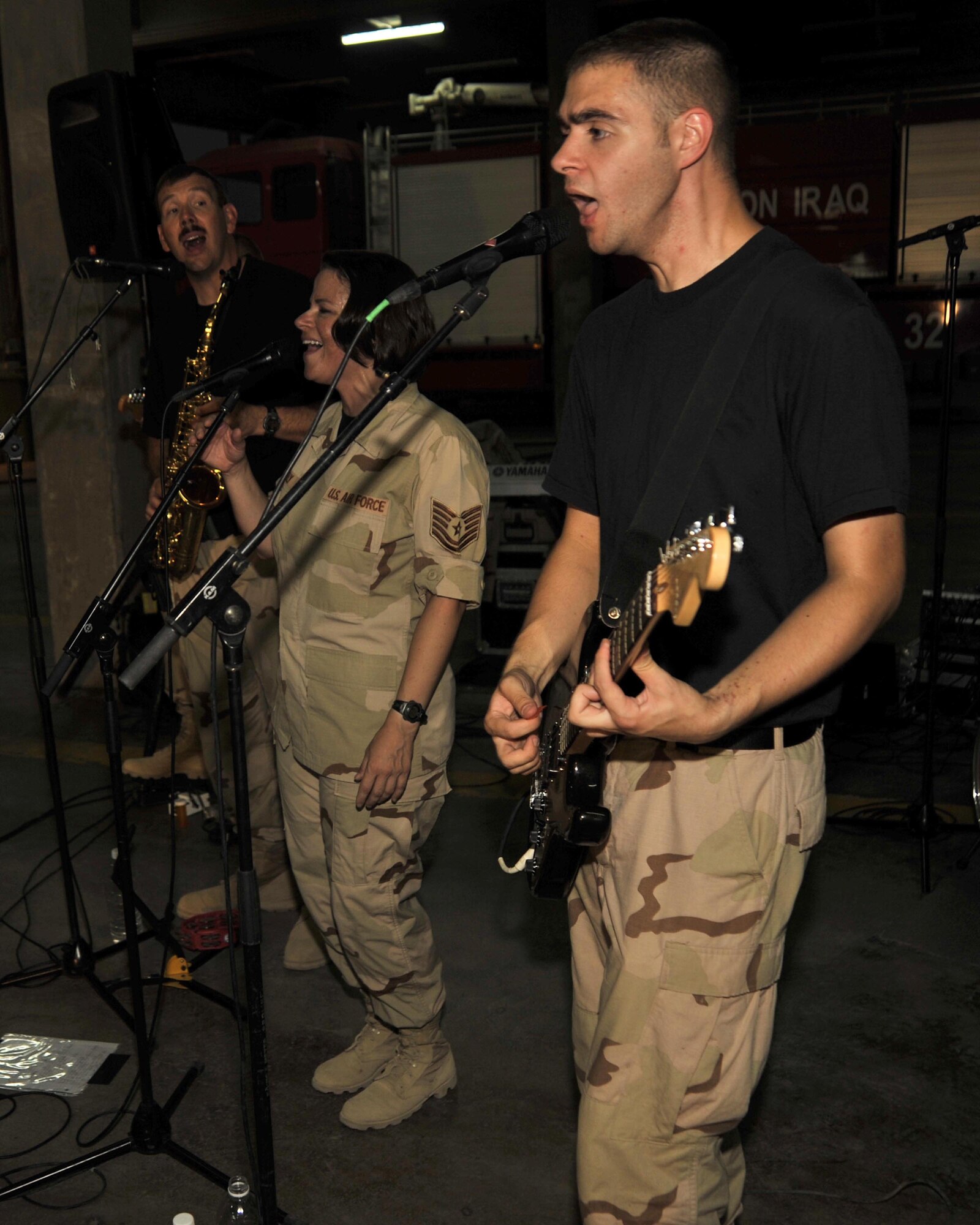 8/30/2008 ? BAGHDAD INTERNATIONAL AIRPORT, Iraq ? Senior Airman Tim Reeder (right), Tech. Sgt. Kim Lively and Master Sgt. Mark Stanaford perform for an audience of Iraqi firefighters in what is most likely the first-ever performance of an American military rock band at Baghdad International Airport. Sergeant Stanaford is the band NCO in charge and saxophone player, Sergeant Lively is the lead vocalist and Airman Reeder is both a guitarist and vocalist for the Air Force Central Command band ?Mirage.? (U.S. Air Force Photo by Master Sgt. Brian Davidson)