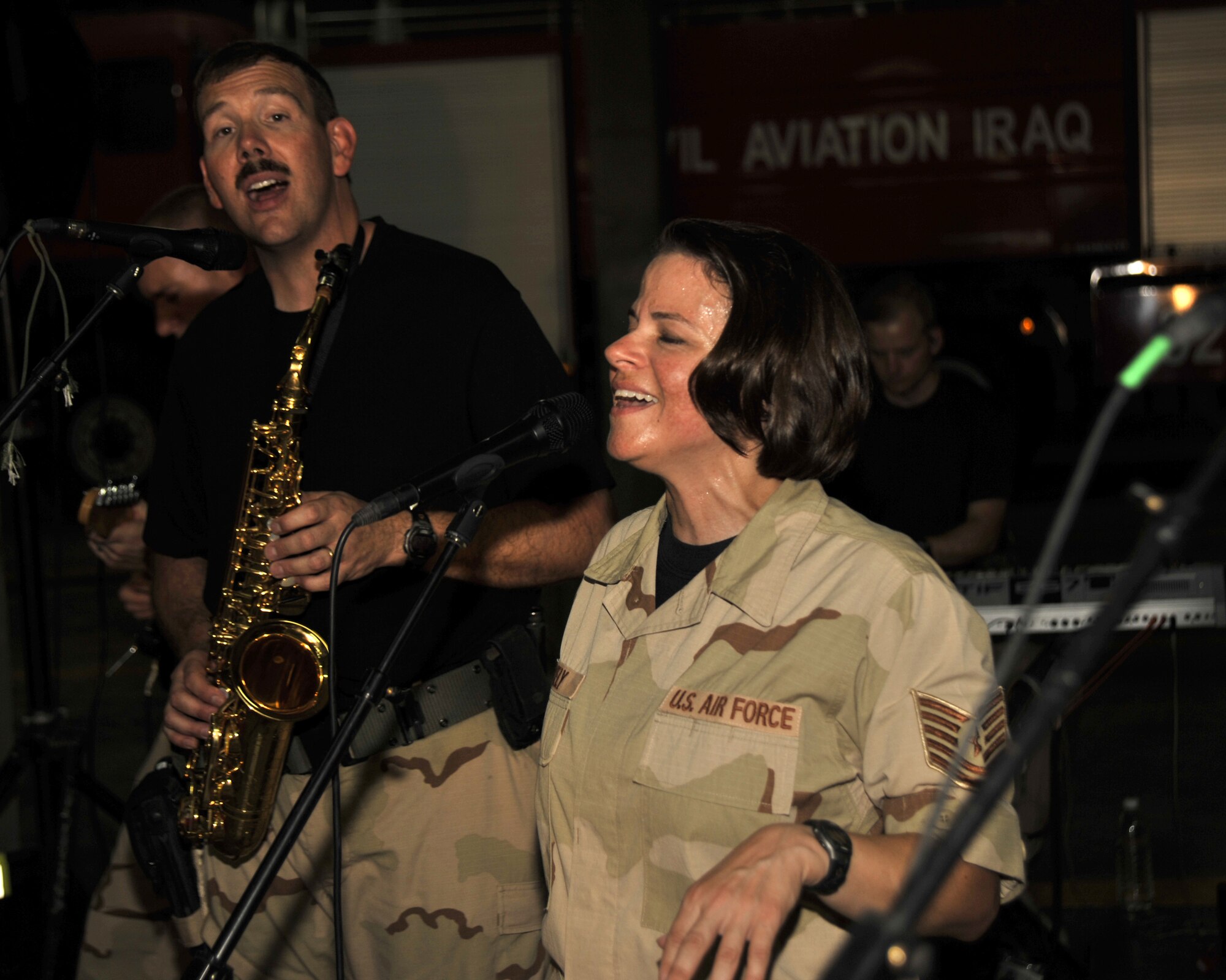 8/30/2008 ? BAGHDAD INTERNATIONAL AIRPORT, Iraq - Tech. Sgt. Kim Lively and Master Sgt. Mark Stanaford perform for an audience of Iraqi firefighters in what is most likely the first-ever performance of an American military rock band at Baghdad International Airport. Sergeant Stanaford is the band NCO in charge and saxophone player and Sergeant Lively is the vocalist for the Air Force Central Command band ?Mirage.? (U.S. Air Force Photo by Master Sgt. Brian Davidson)