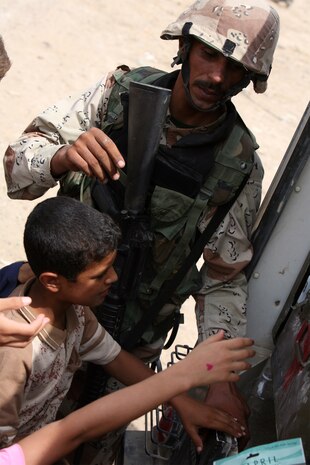 JIKO, Iraq (August 30, 2008) – A soldier with 2nd Battalion, 2nd Brigade, 1st Iraq Army Division, hands out toys and school supplies to children during a combined medical engagement (CME) Aug. 30. The Tri-Cities City Council hosted the event with support and assistance from 2nd Battalion, 2nd Brigade, 1st Iraq Army Division, Iraq Police and Marines with Mobile Assault Company, 1st Battalion, 2nd Marine Regiment, Regimental Combat Team 1. (Official U.S. Marine Corps photo by Lance Cpl. Scott Schmidt)