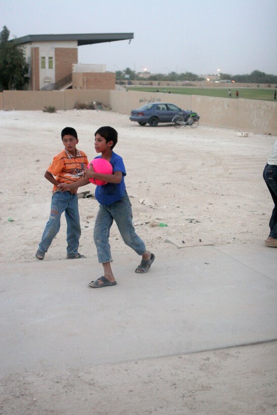 A young boy protects his soccer balls outside the newly opened Anah Youth Center in Anah, Iraq, Aug. 30. Marines with Civil Affairs Team 5, Detachment 1, 2nd Battalion, 11th Marine Regiment, Regimental Combat Team 5 handed out over 60 soccer balls to the children of Anah. The balls were donated as a part of the Kick for Nick foundation, a foundation started in memory of Army Pfc. Nick Madaras, who was killed Sept. 3, 2006, in Iraq. The center had been previously used as a military outpost by Coalition forces.