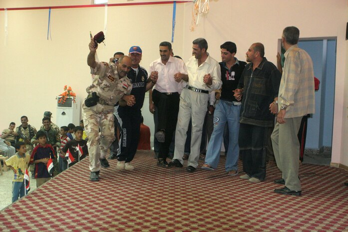 Members of the Anah, Iraq, community show their enthusiasm at the grand opening of the Anah Youth Center Aug. 30. The center will function as a place where the children of Anah can go to play sports and have fun in a safe environment. It will also provide a venue where public speakers can come to teach classes and the local schools will be able to use the auditorium for classes. The center had been previously used as a military outpost by Coalition forces.