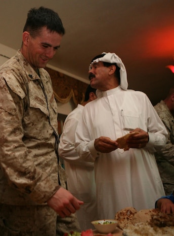 Cpl. Jack D. Jacoby, a rifleman with Company L, 3rd Battalion, 4th Marine Regiment, Regimental Combat Team 5, enjoys an Iraqi Dinner with Sheik Sheik Khalif Awwad Farhan in Hit, Iraq, Sept. 2. Marines with 3rd Bn., 4th Marines escorted key leaders from 3rd Bn., 7th Marines to Sheik Khalifâ??s home to introduce the two parties. The Marines with 3rd Bn., 7th Marines are relieving 3rd Bn., 4th Marines in Iraq.::r::::n::