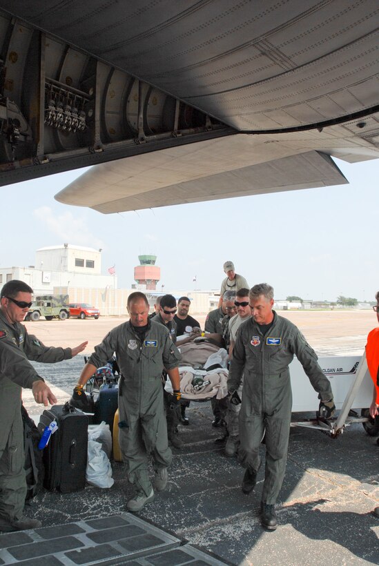 Members from the 136 Airlift Wing, Texas Air National Guard carry a special needs person to a C-130 belonging to the 136 AW  that is awaiting to airlift evacuees to safety at the SE Texas Regional Airport, Beaumont , Texas, in support of Hurricane Gustav Relief efforts, 30 August 2008. (photo by TSgt Charles Hatton)